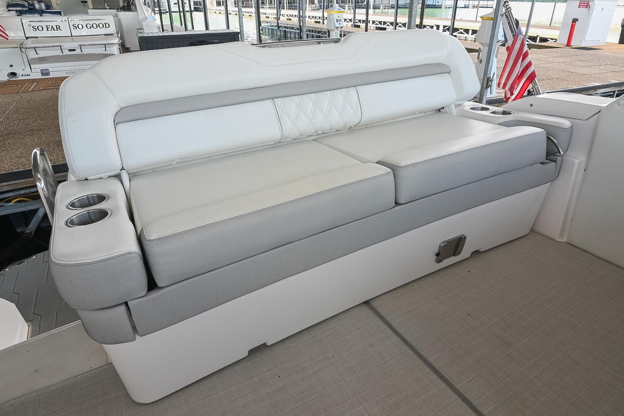 2021 Regal 33 Express boat seating with cup holders and American flag in marina.