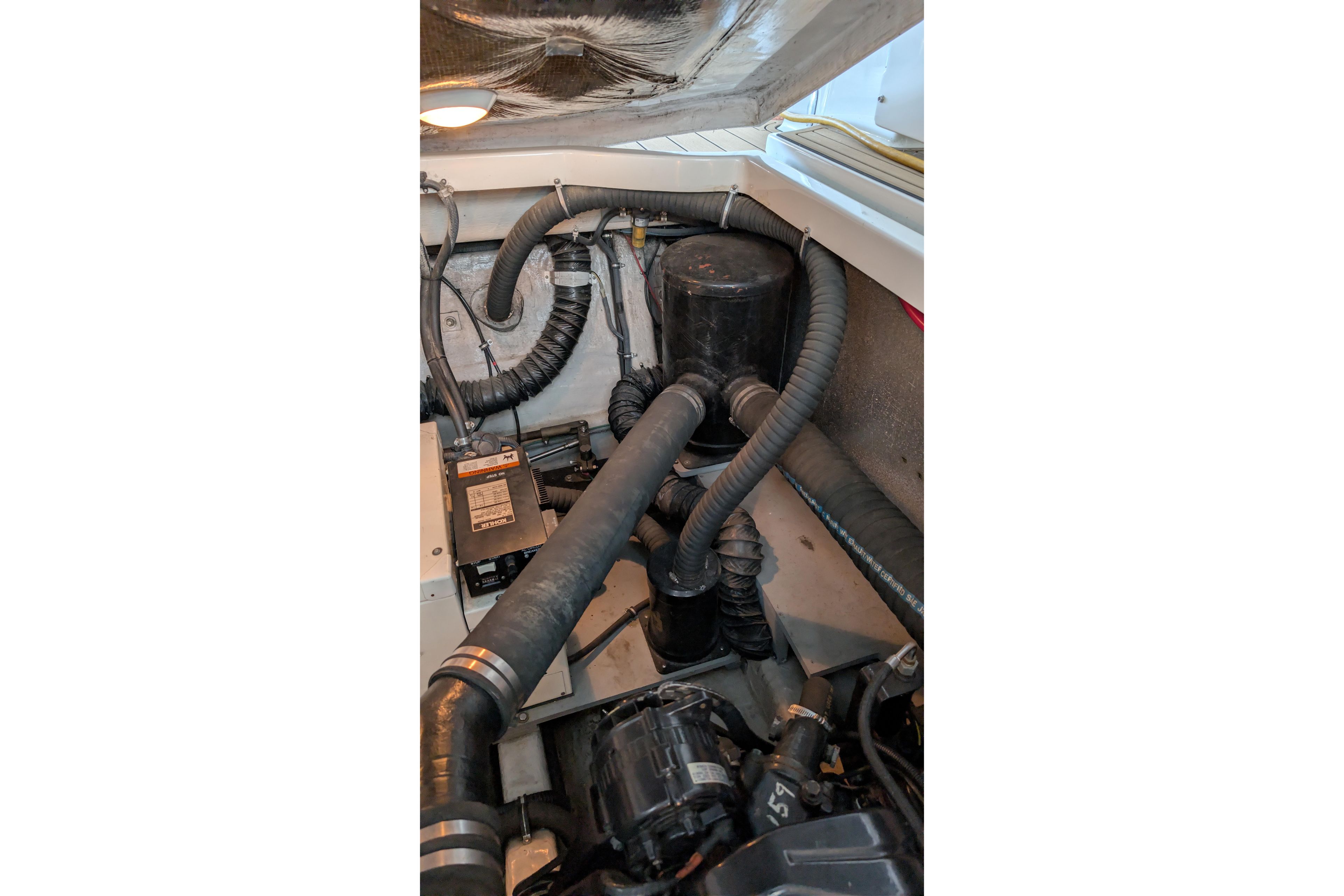 Engine compartment of a 2001 Wellcraft 3300 Martinique boat, showing hoses and components.