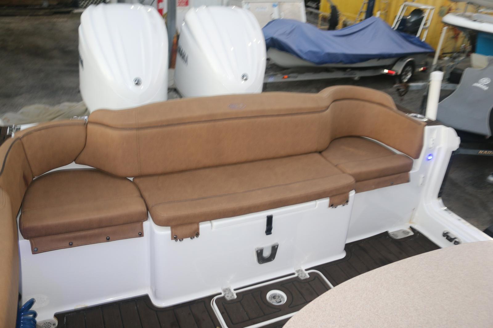 2022 Sea Hunt Ultra 305 SE boat with brown cushioned seating and dual outboard motors.
