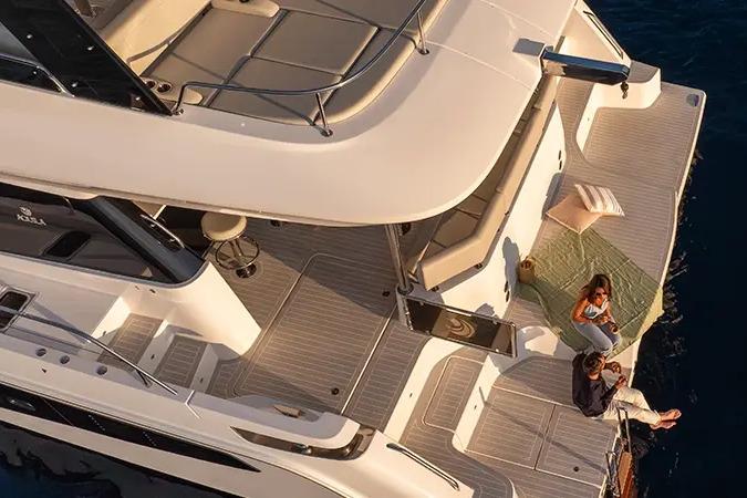 Manufacturer Provided Image: 2025 Aquila 46 Yacht deck with people relaxing, showcasing luxury and comfort.