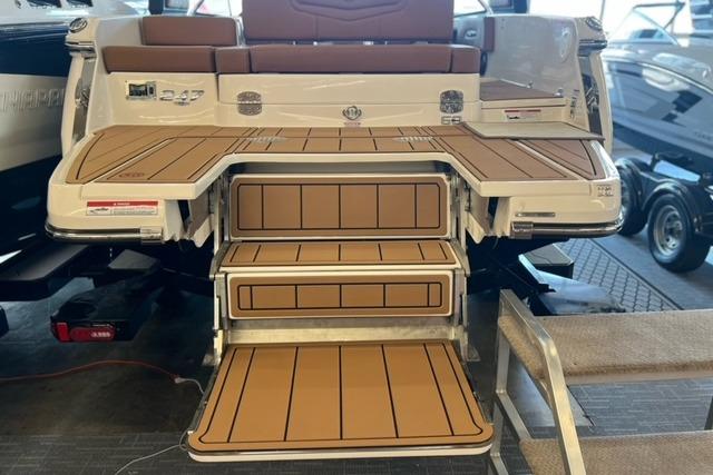 2025 Chaparral 247 SSX boat with teak-style swim platform and steps in showroom.