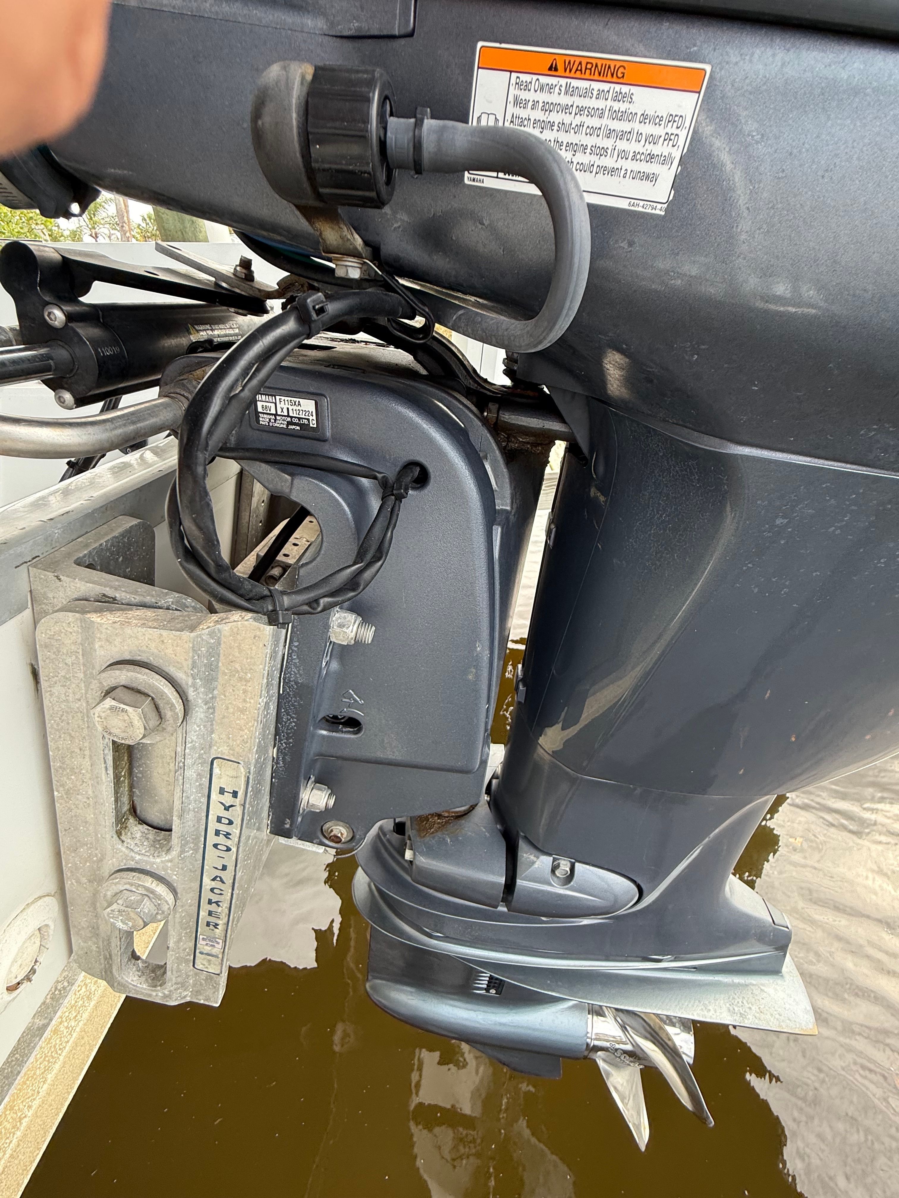 Close-up of a boat's outboard motor with propeller in the water.