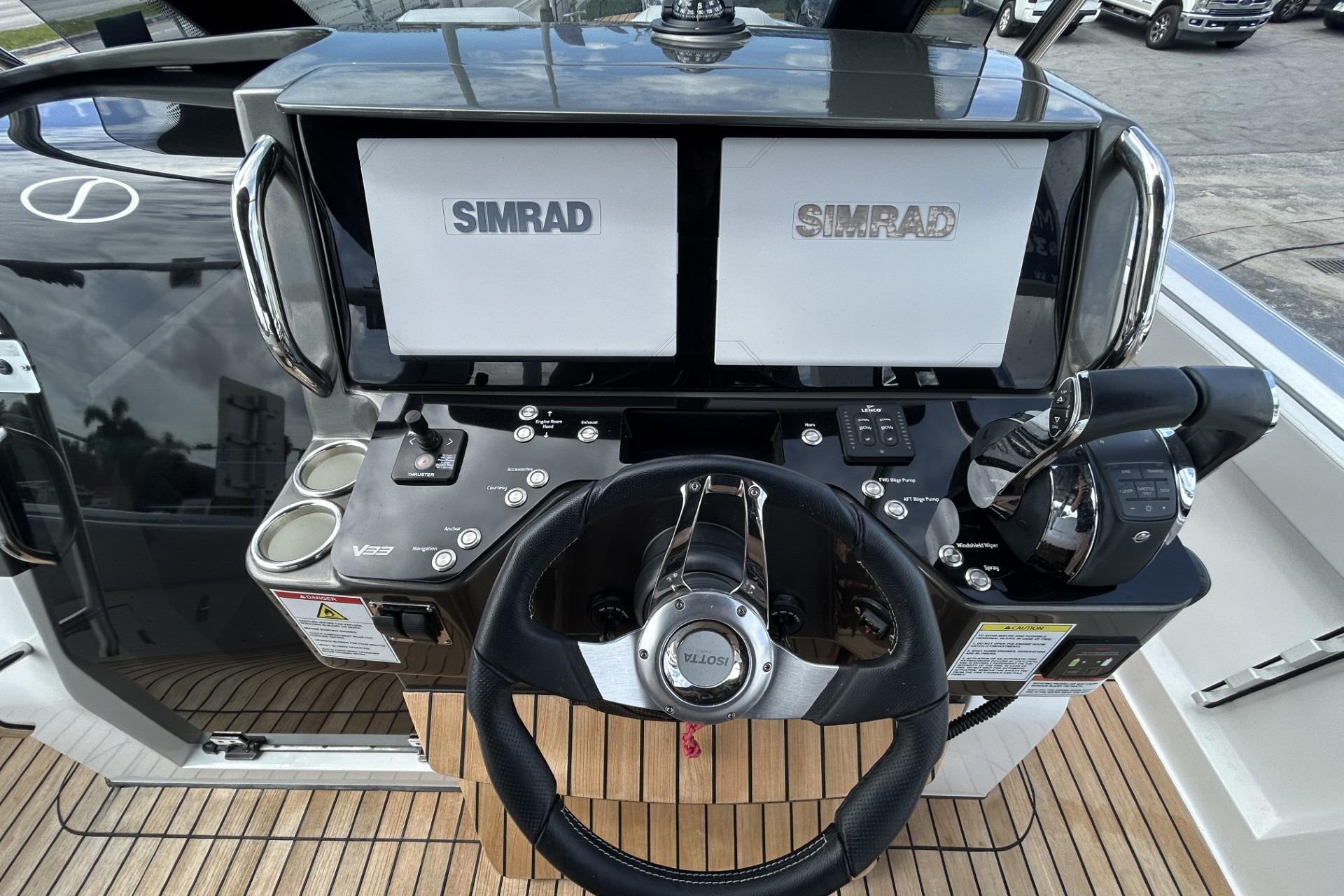 Helm of 2023 Schaefer V33 boat with dual Simrad displays and modern controls.