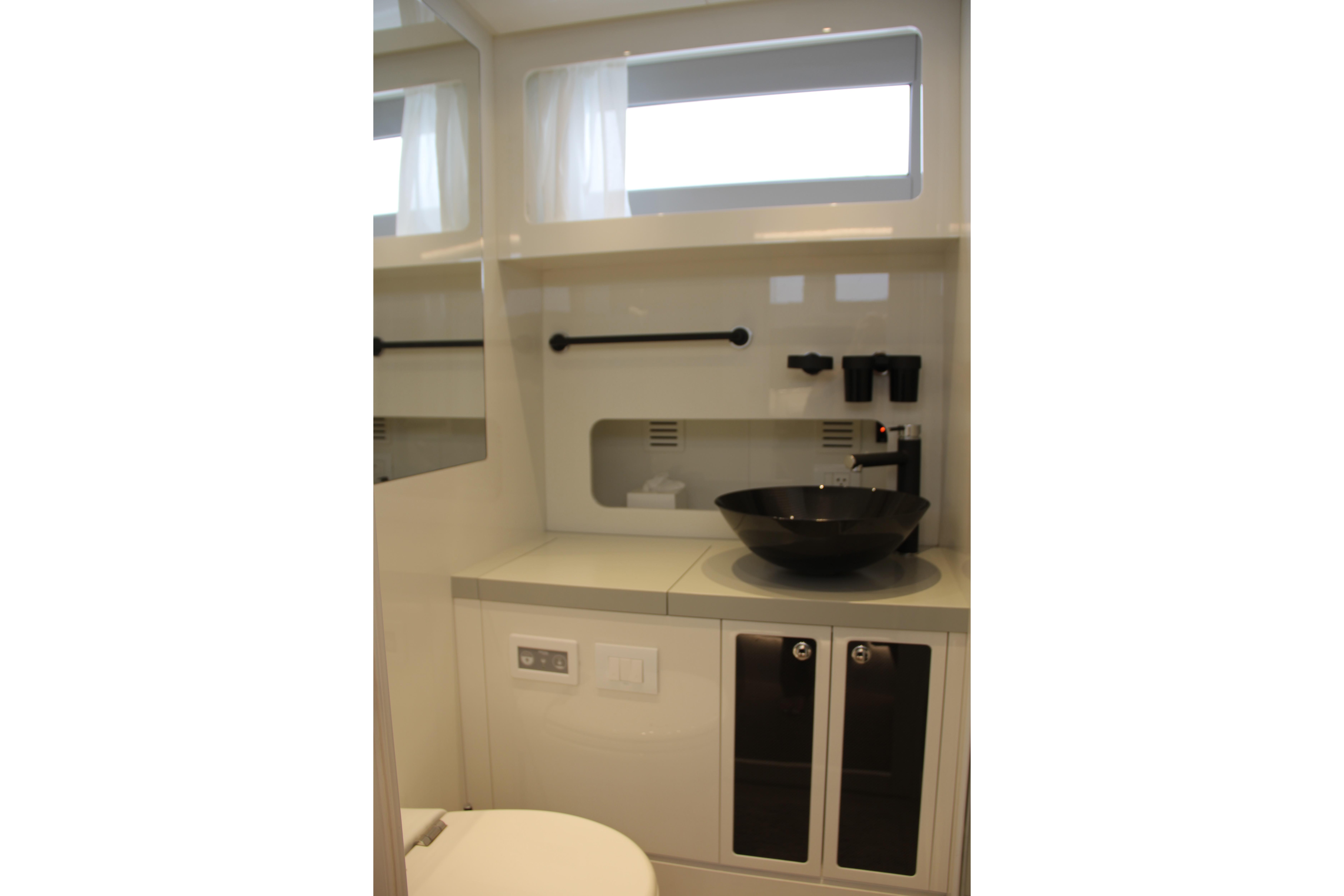 Modern bathroom interior of 2023 Canados 493 Gladiator yacht with sleek black sink.