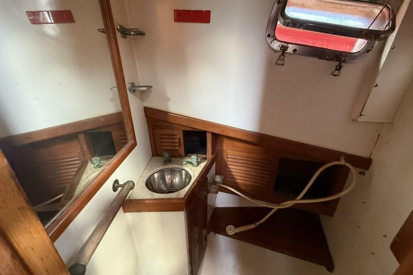 Compact bathroom in 1986 Lord Nelson 37 #49 yacht with sink and mirror.