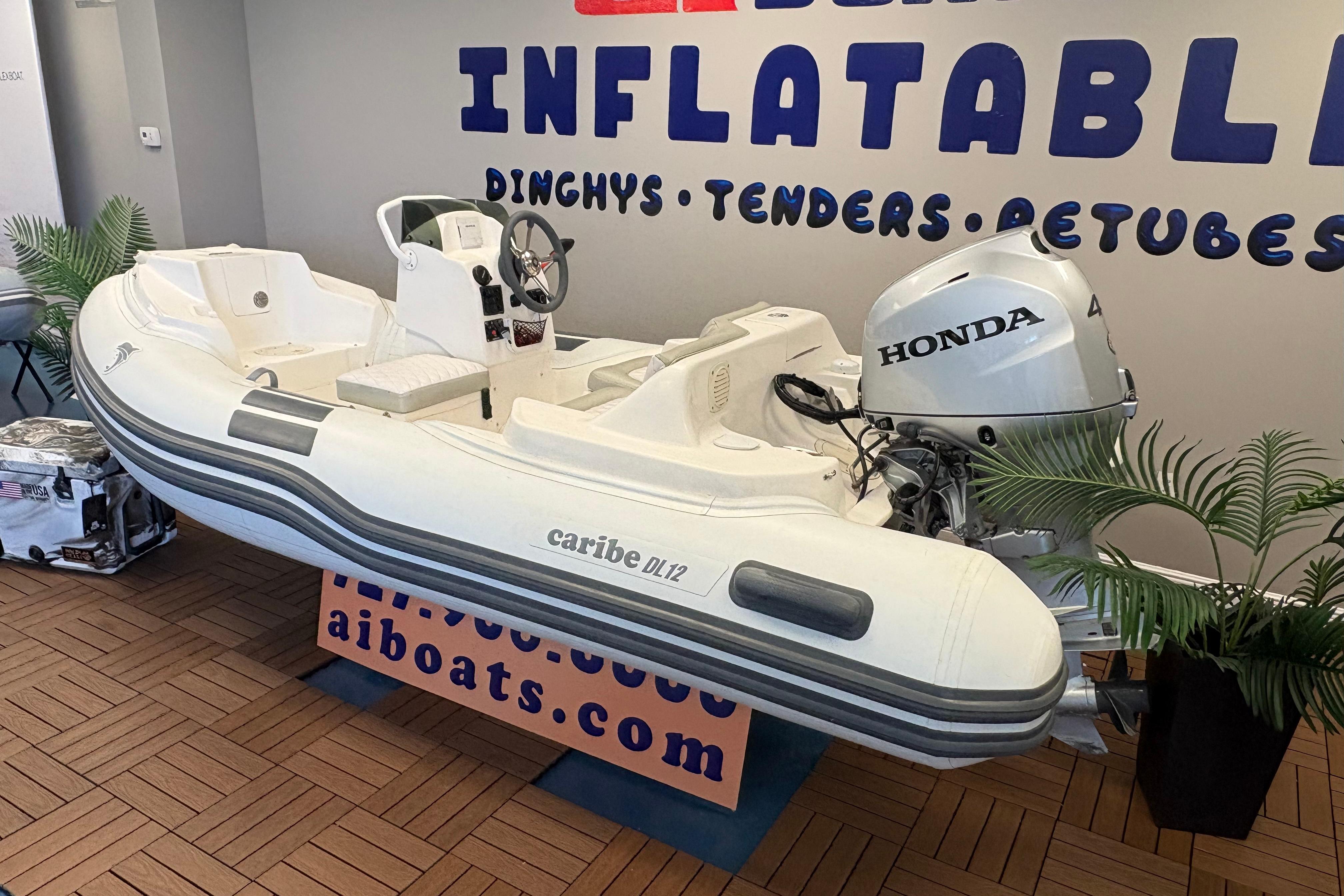 2019 Caribe DL12 inflatable boat with Honda motor displayed indoors.