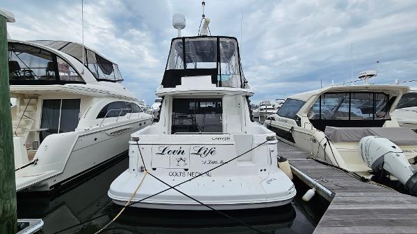 2000 Carver 450 Voyager Pilothouse yacht docked at marina, rear view.