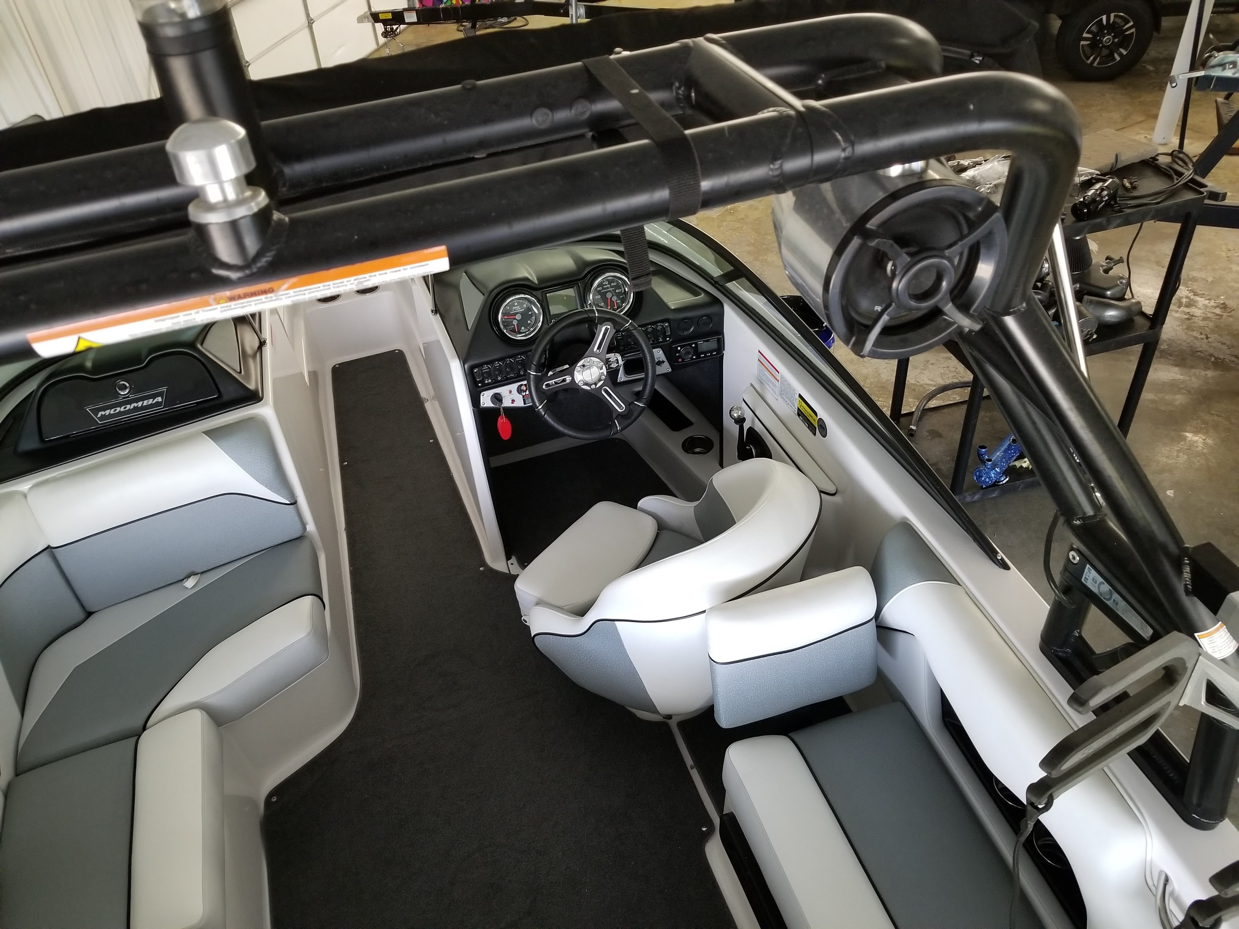 Interior view of a 2016 Moomba Mondo with gray and white seating and a modern helm.