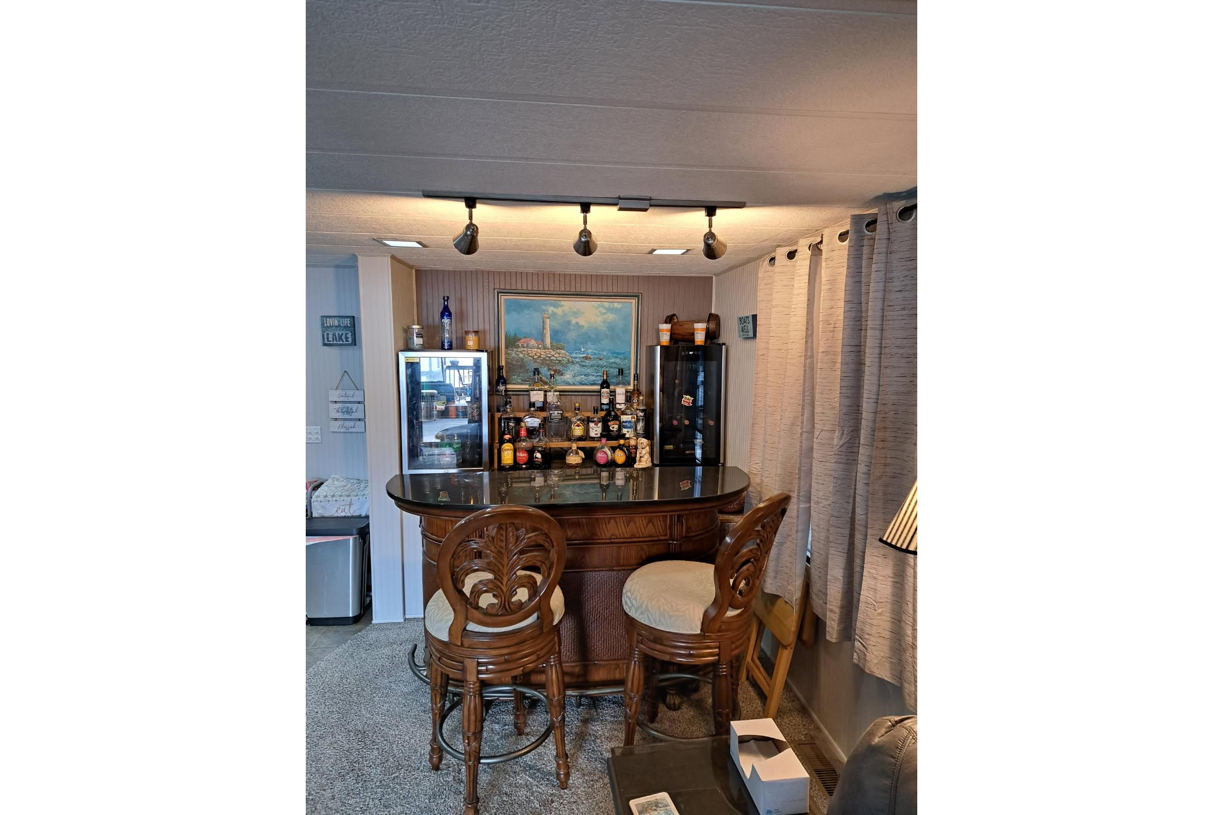 Bar area inside a 1990 Sumerset 16 x 70 houseboat with elegant wooden stools.