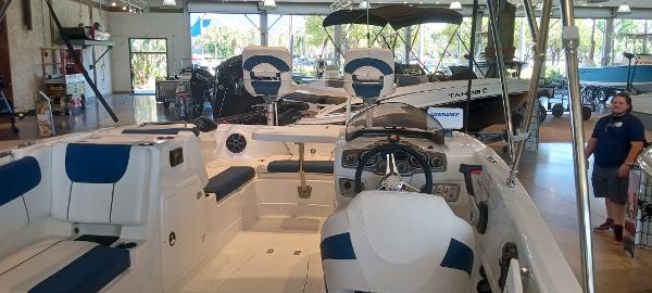 2024 Tahoe 1950 boat interior in showroom, featuring blue and white seating.
