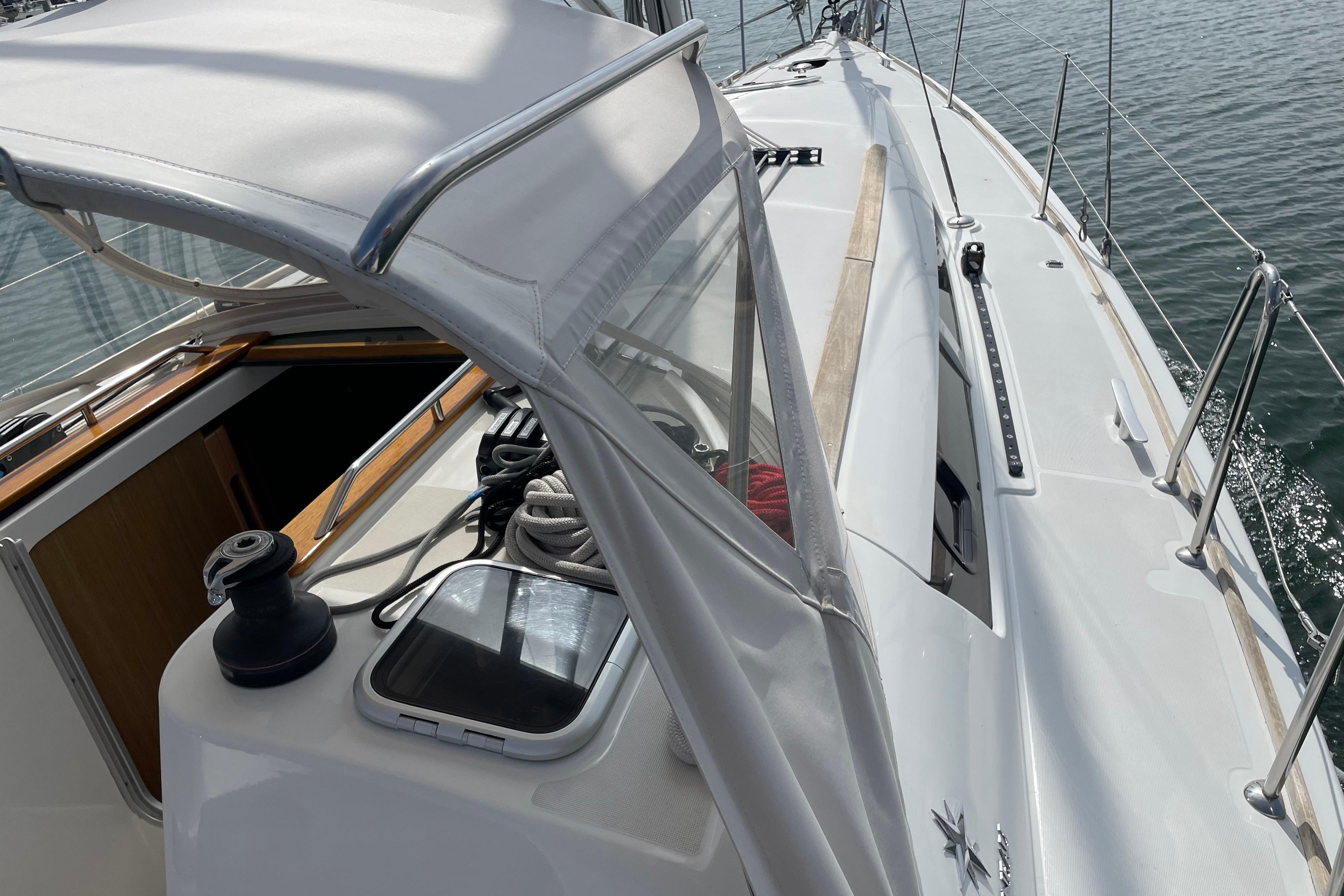 2007 Jeanneau Sun Odyssey 39 DS sailboat deck with winch and ropes, docked on calm water.