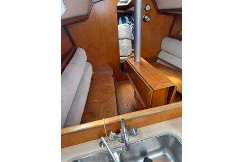 Interior of 1986 Beneteau First 305 sailboat with wooden cabinetry and seating.