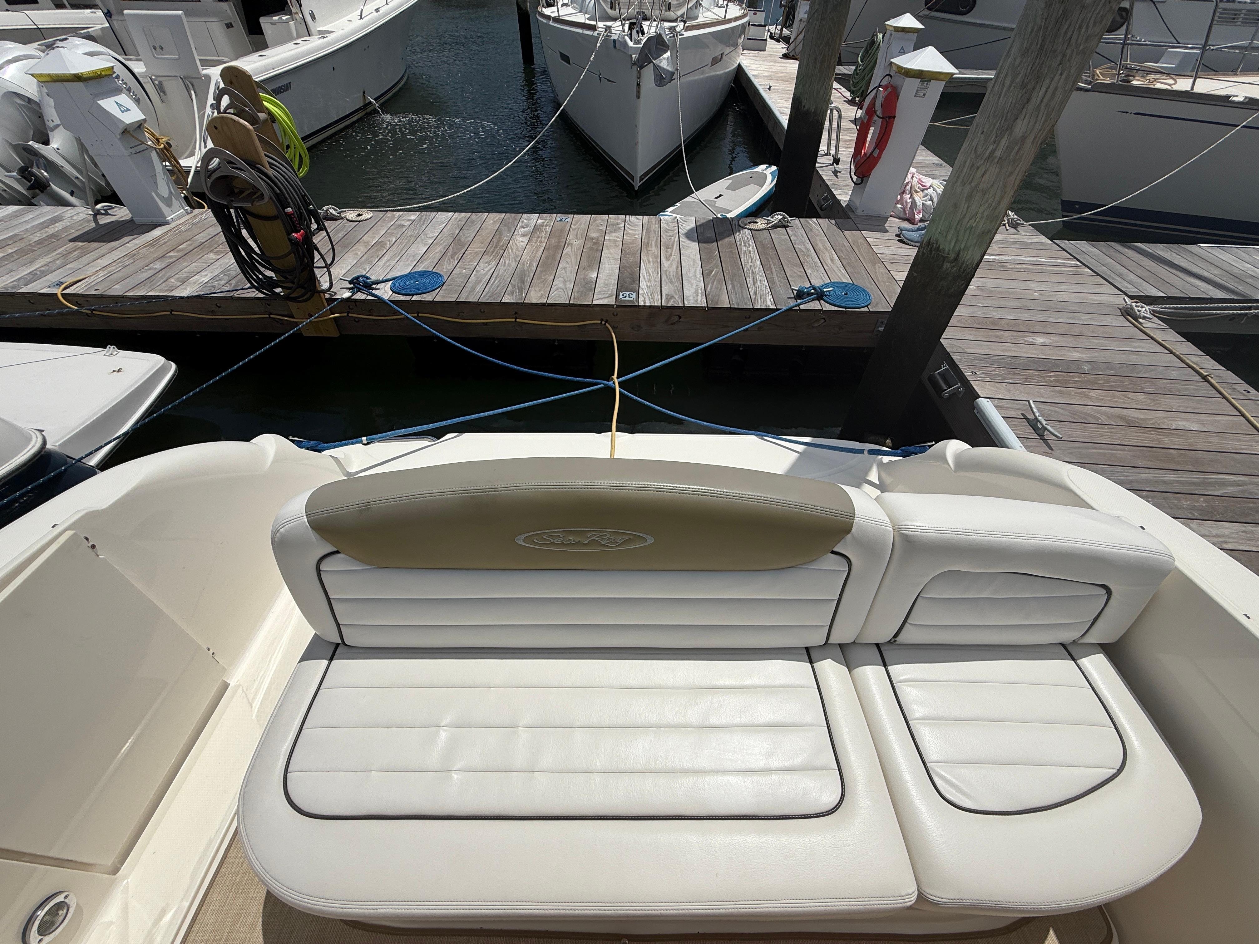 2006 Sea Ray 290 Sundancer boat interior with white seating at marina dock.