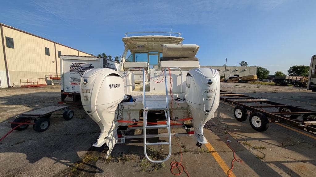 2016 World Cat 320 DC boat with twin Yamaha 300 engines in a marina setting.