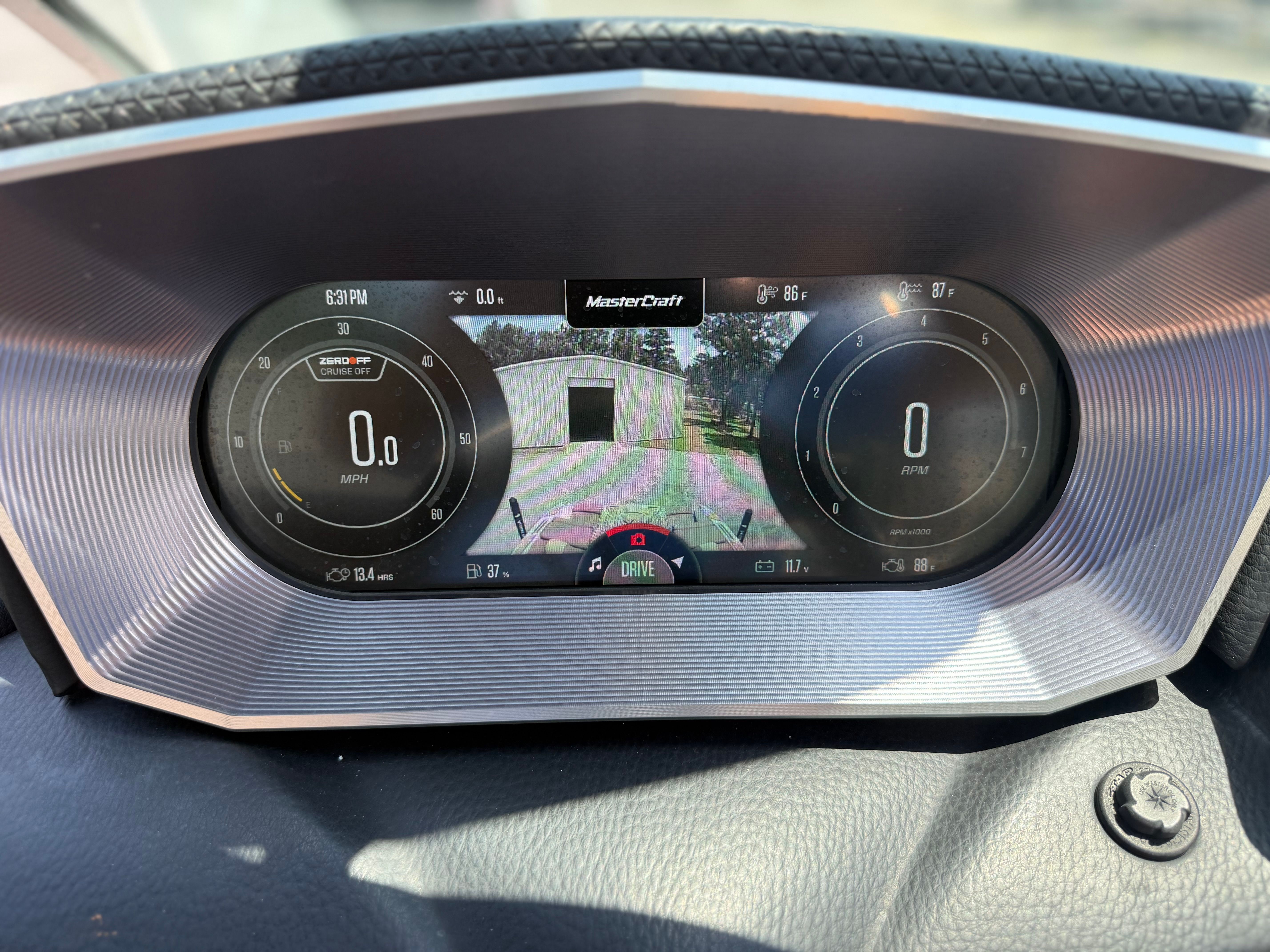The dashboard of a MasterCraft X24 boat displays digital gauges and a rearview camera.