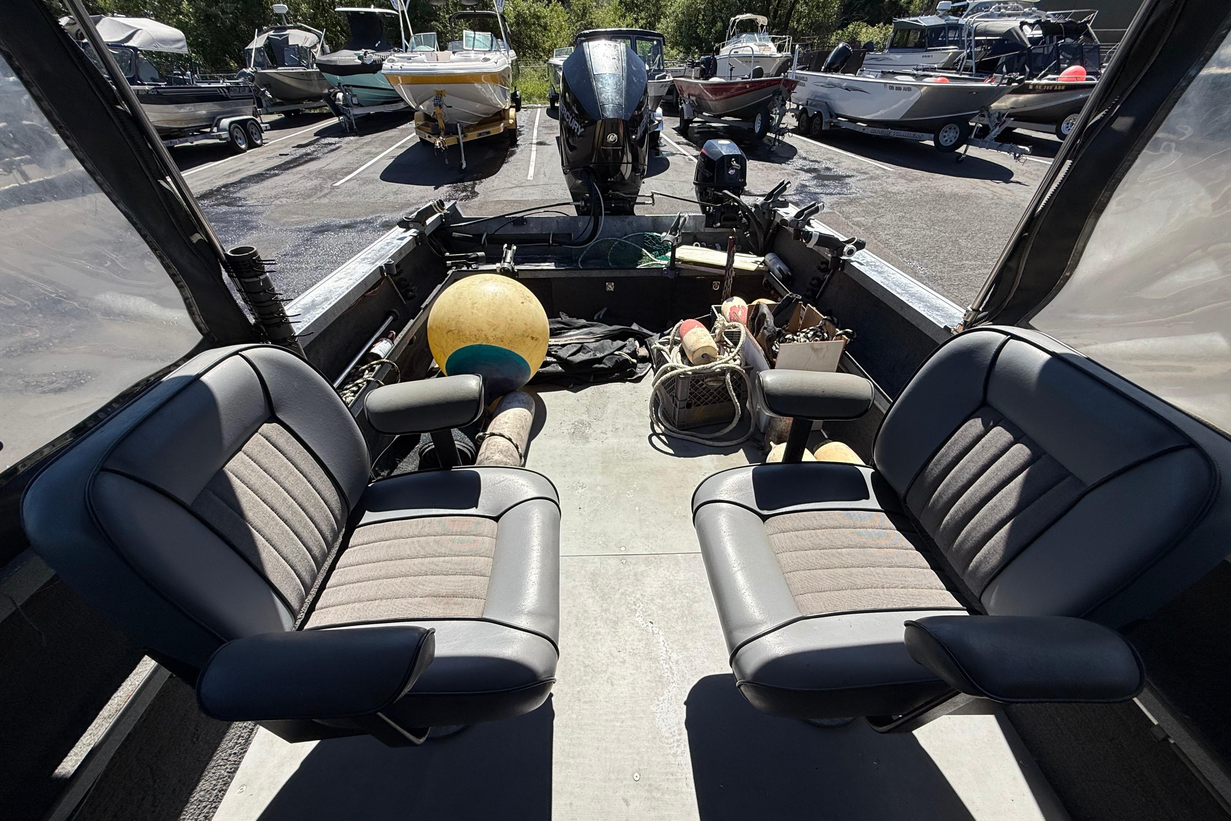 2004 Alumaweld Intruder Outboard 20 boat interior with seating and fishing gear.