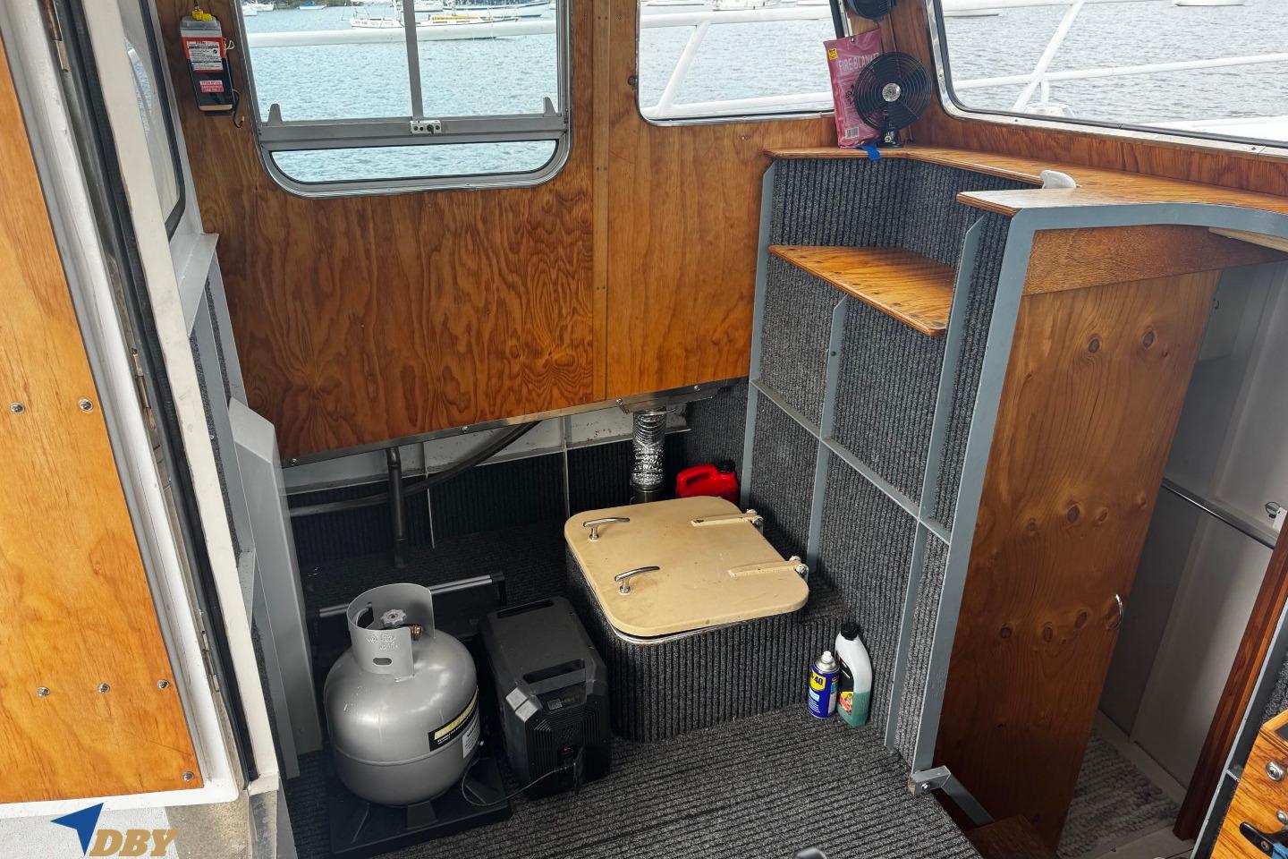 Interior of a 1999 Boden 34 boat with wooden paneling and storage area.