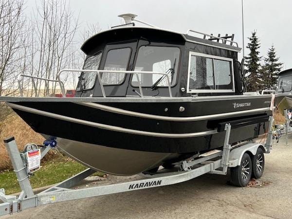 2024 Spartan 220 Maximus boat on Karavan trailer, parked outdoors.
