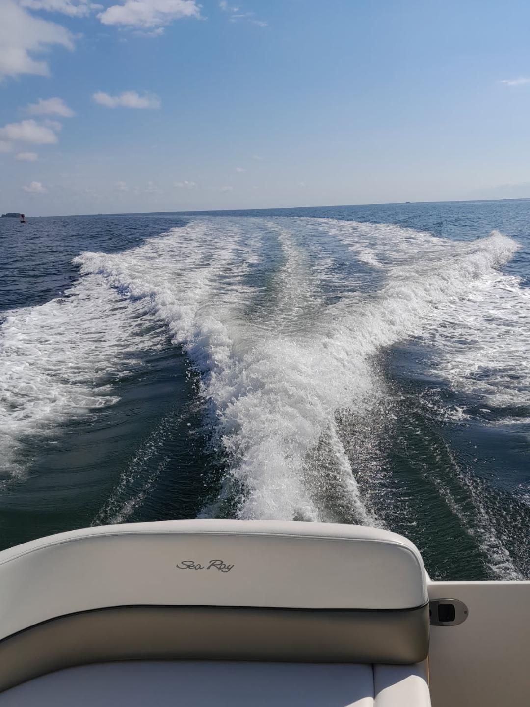 A 2005 Sea Ray Sundancer 260 cruising on open water, leaving a frothy wake behind.