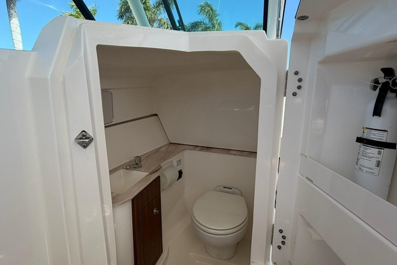 2021 Pursuit DC 266 Dual Console boat interior with toilet and sink.