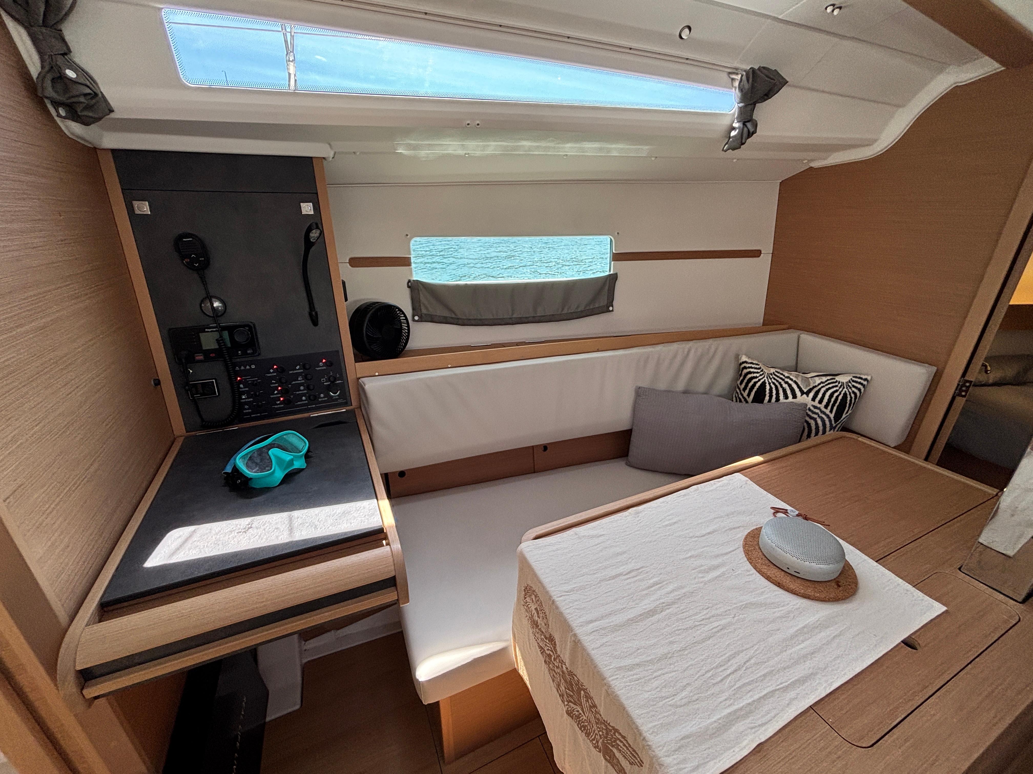 Interior of 2023 Jeanneau Sun Odyssey 349 sailboat with cozy seating and navigation station.
