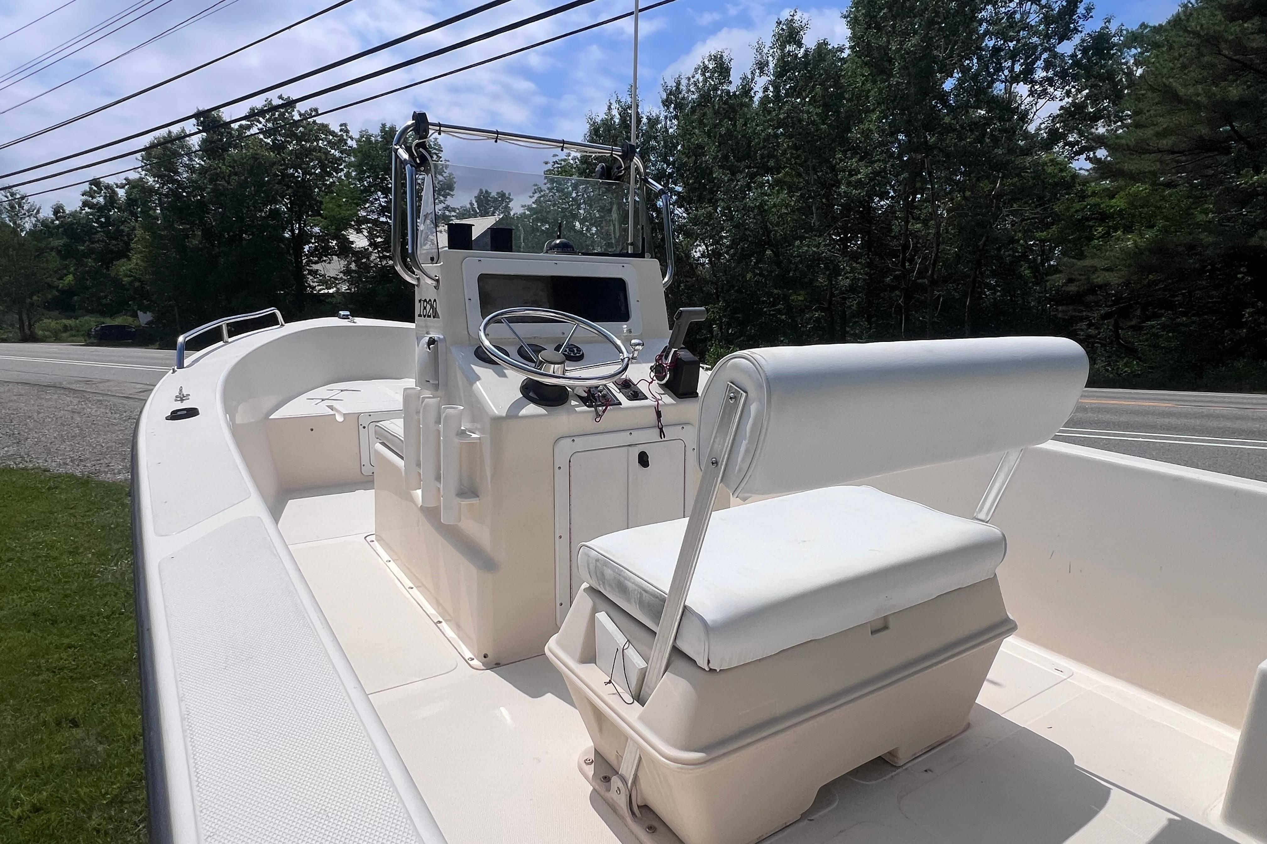 2003 May-Craft 1820CC boat interior with steering console and seating, parked near a road.
