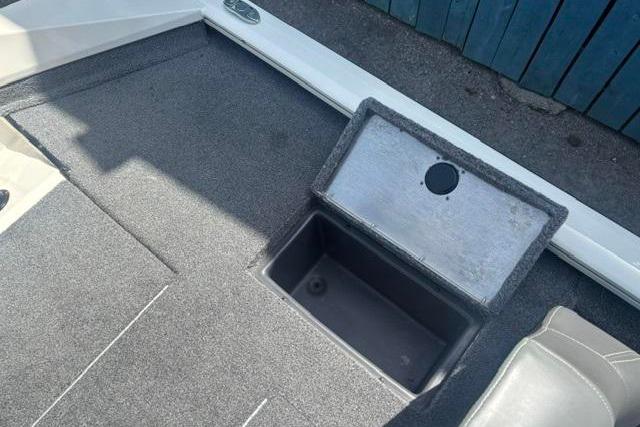 2021 Tracker Pro Team 175 TXW Tournament Edition boat storage compartment, open lid, gray interior.