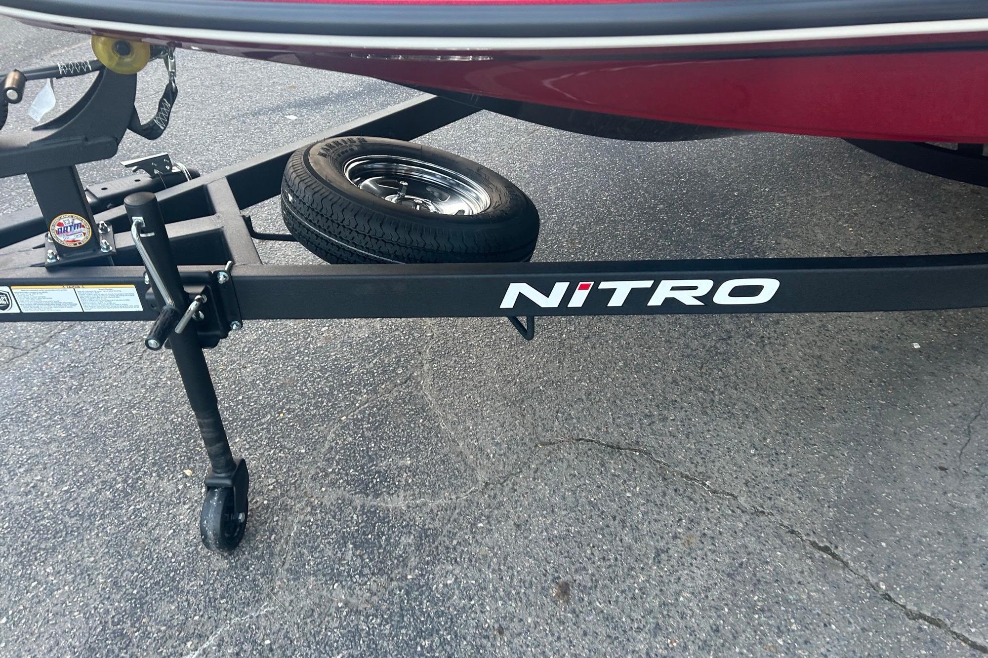 Trailer of a 2026 Nitro Z17 boat with spare tire on asphalt.