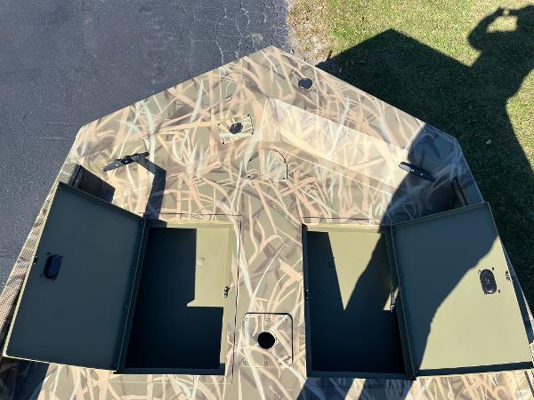 2025 Lowe Roughneck 1760 boat with open storage compartments, camo pattern.