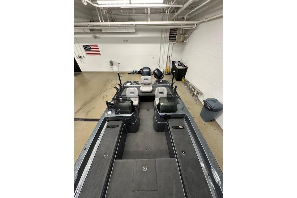 1999 Stratos 219 CF boat interior in a garage with American flag on wall.