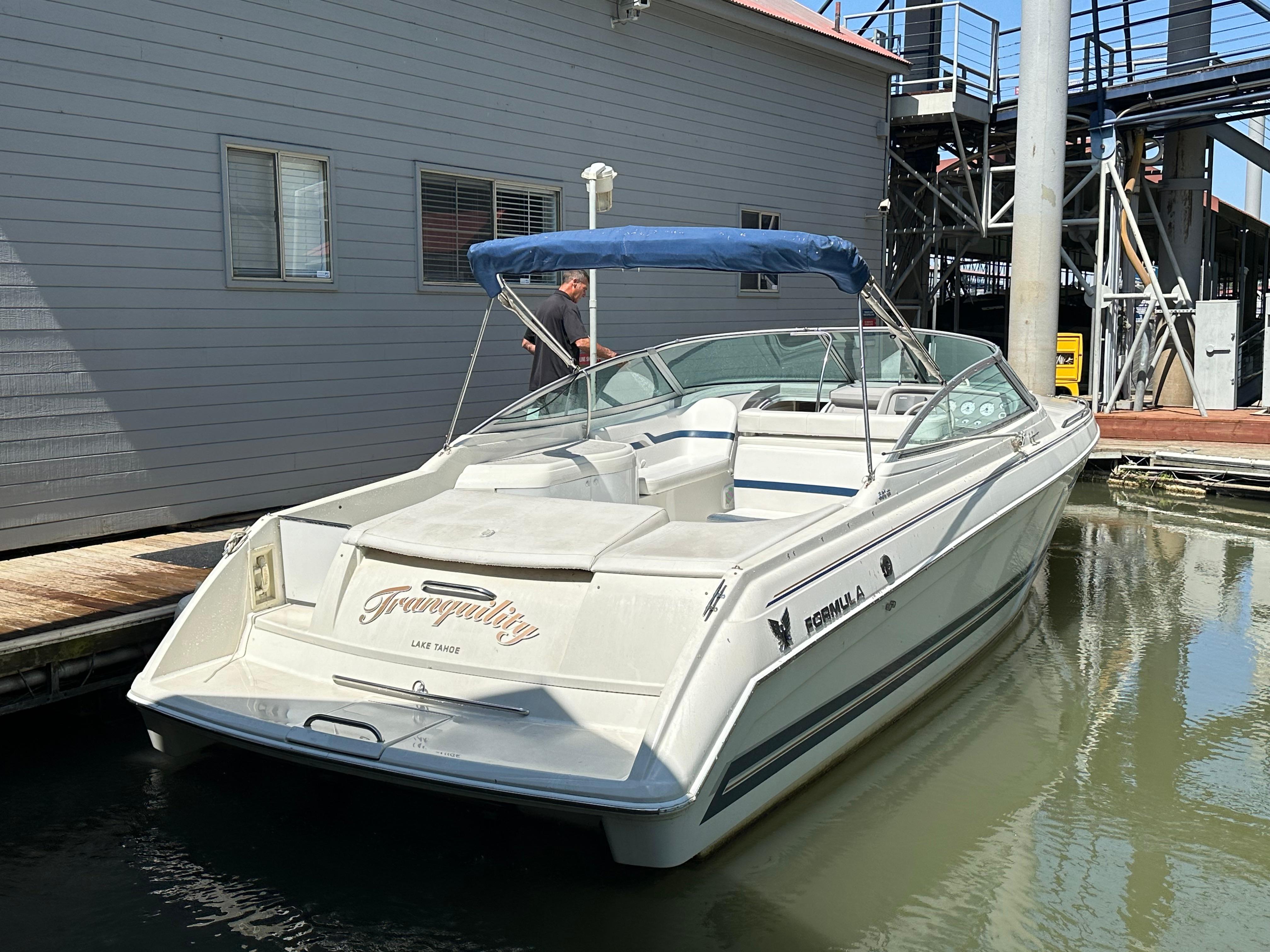 2000 Formula 330 SS boat docked with blue canopy and sleek design.