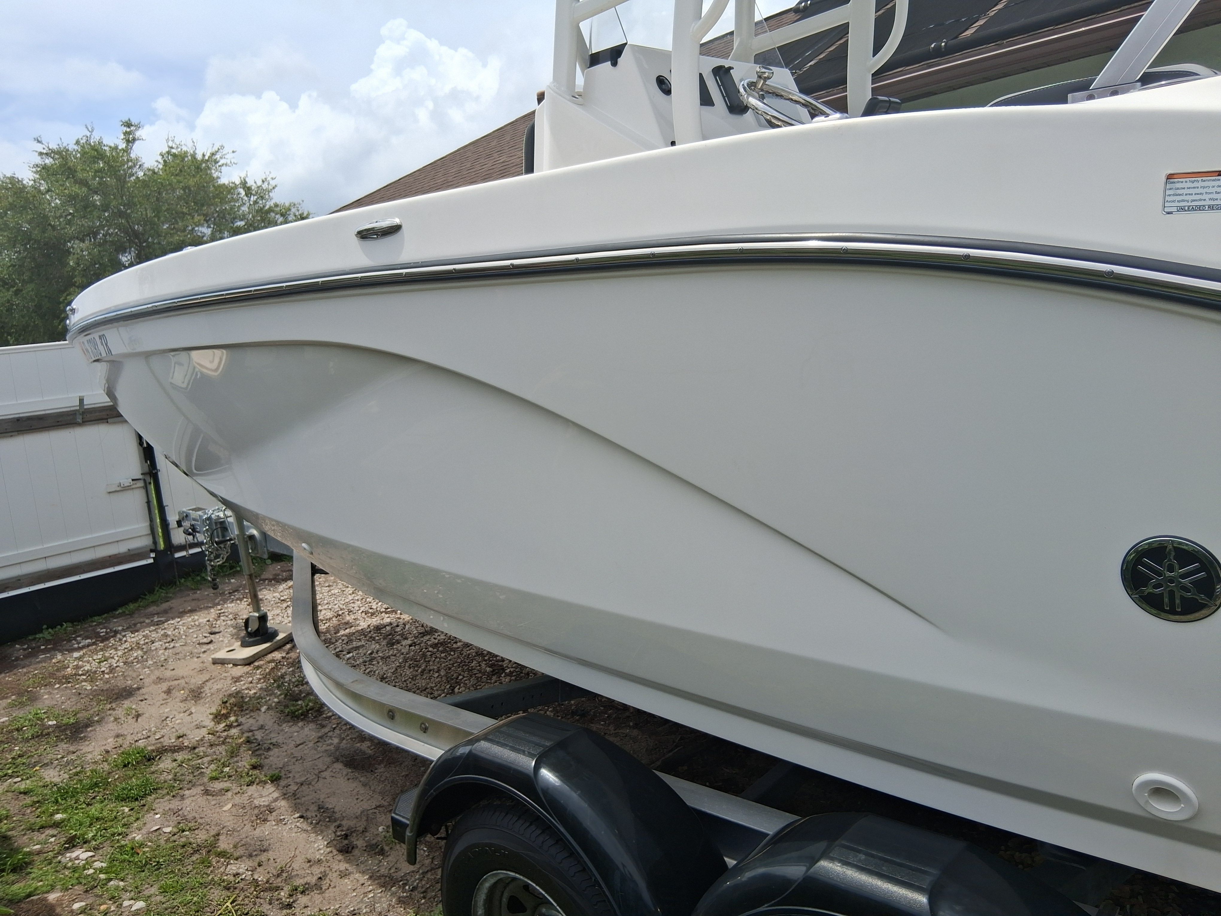 A 2023 Yamaha 220 FSH Sport boat on a trailer outdoors.