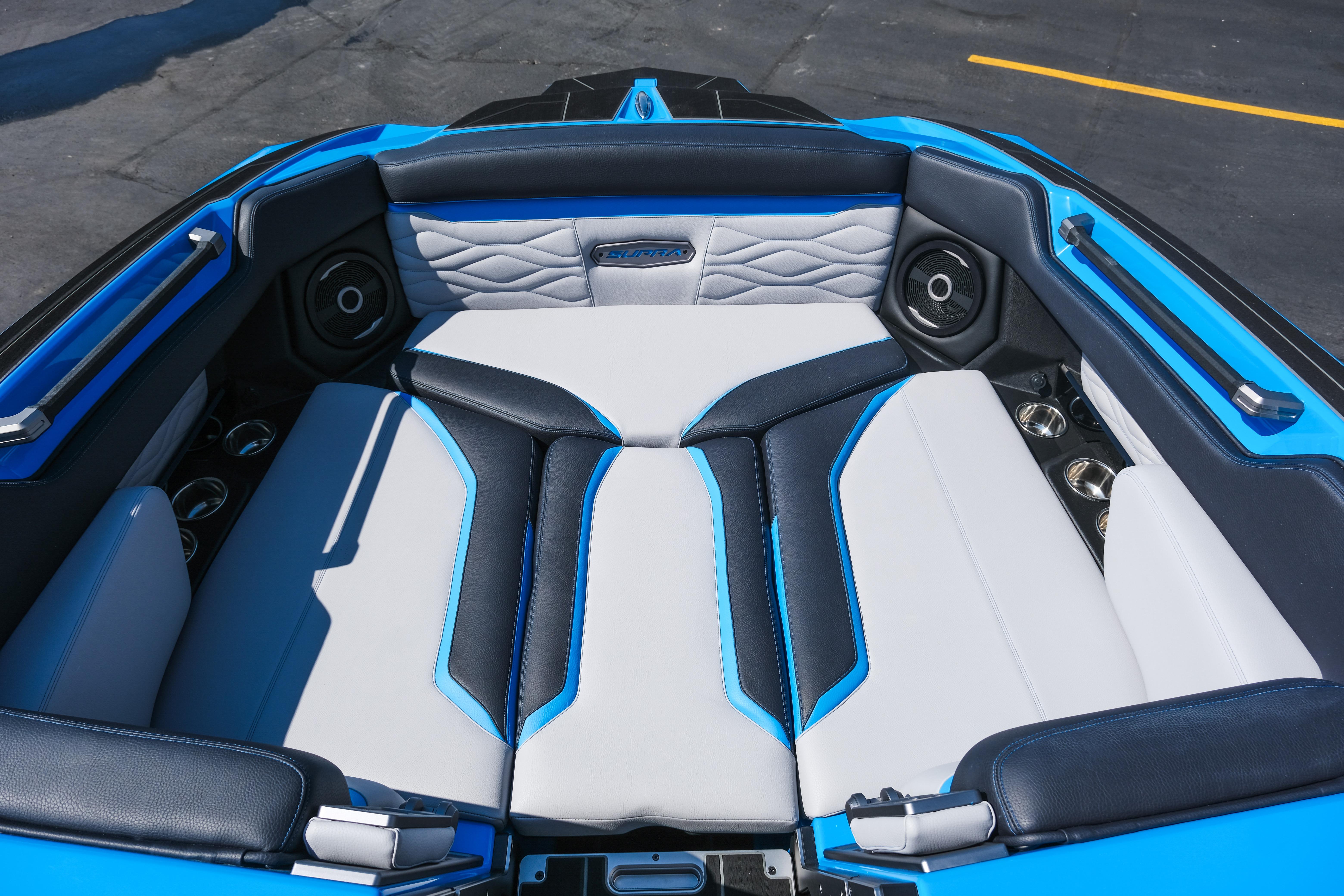 2026 Supra SA450 boat interior with blue and white seating, featuring premium speakers.