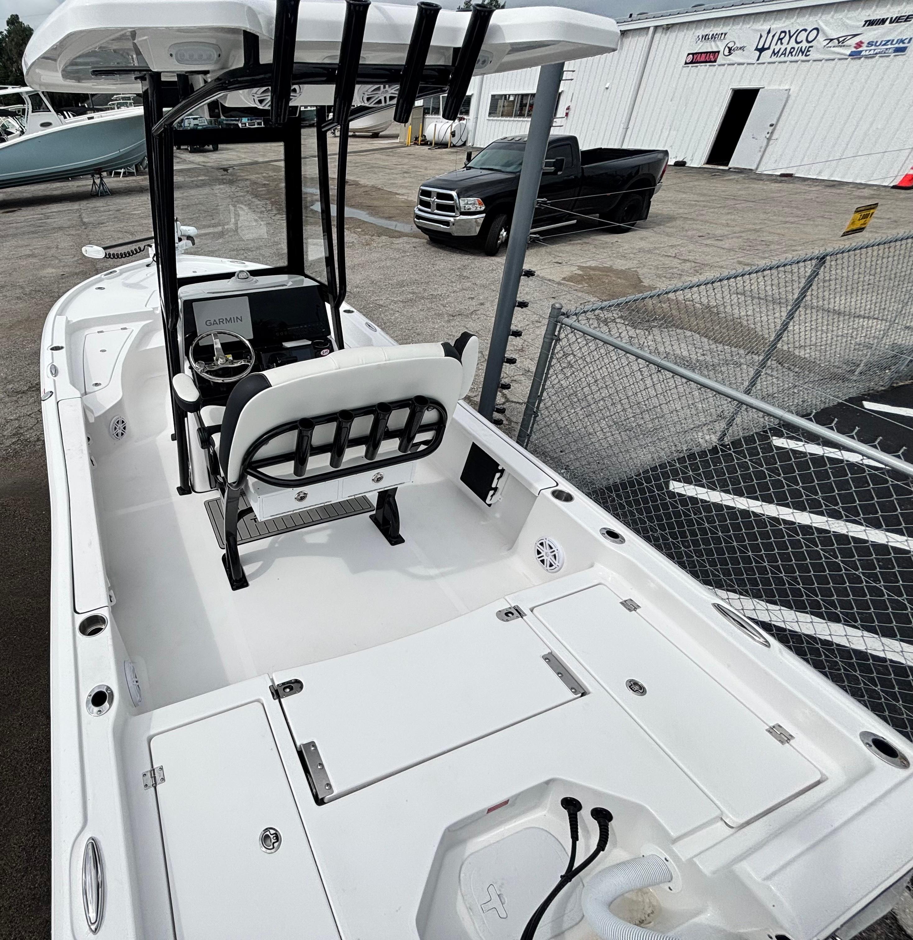 2026 Tidewater 2210 Carolina Bay boat with center console and seating, parked near a fence.