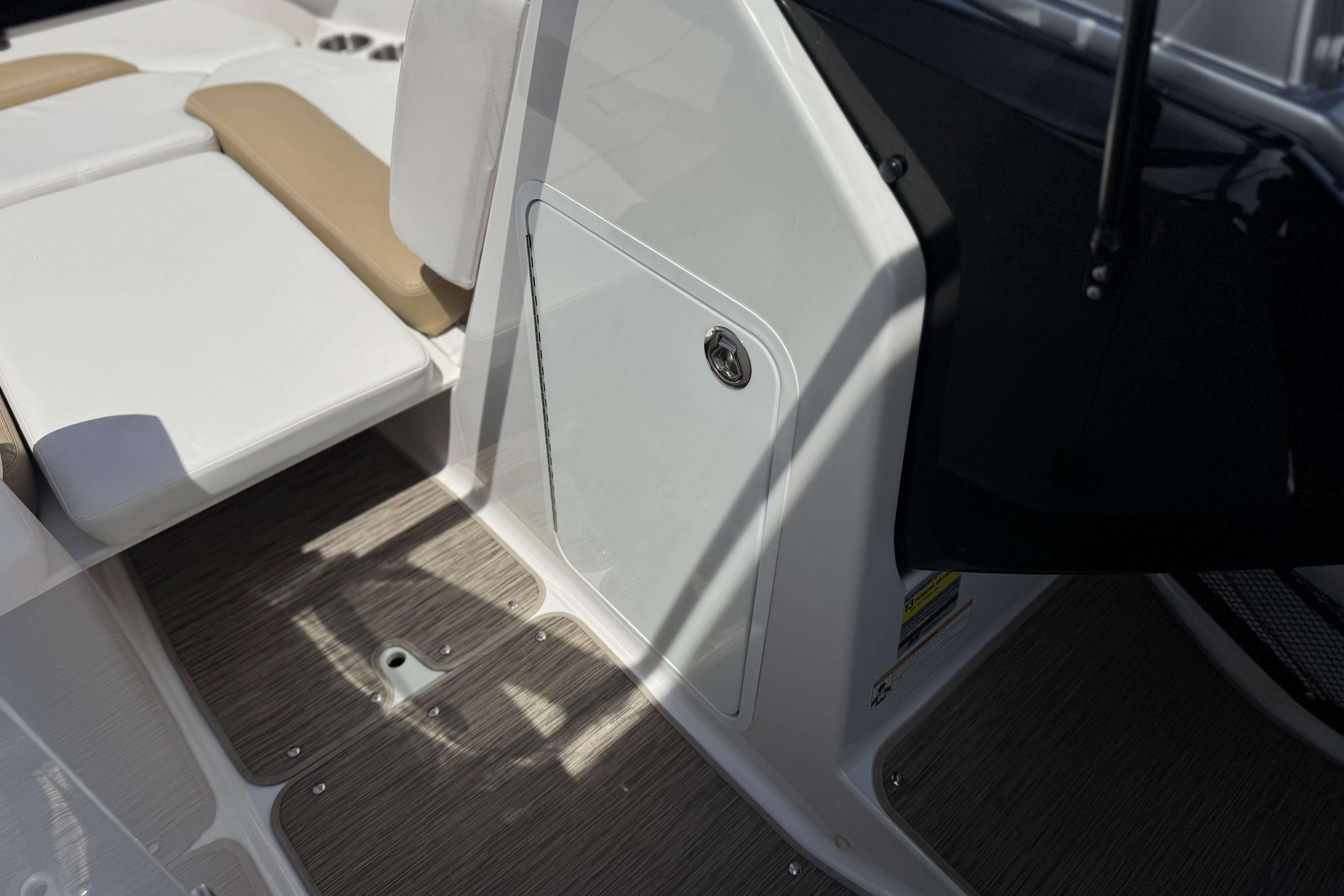 Interior view of 2017 Scarab 255 H.O. Platinum boat, featuring seating and storage compartment.