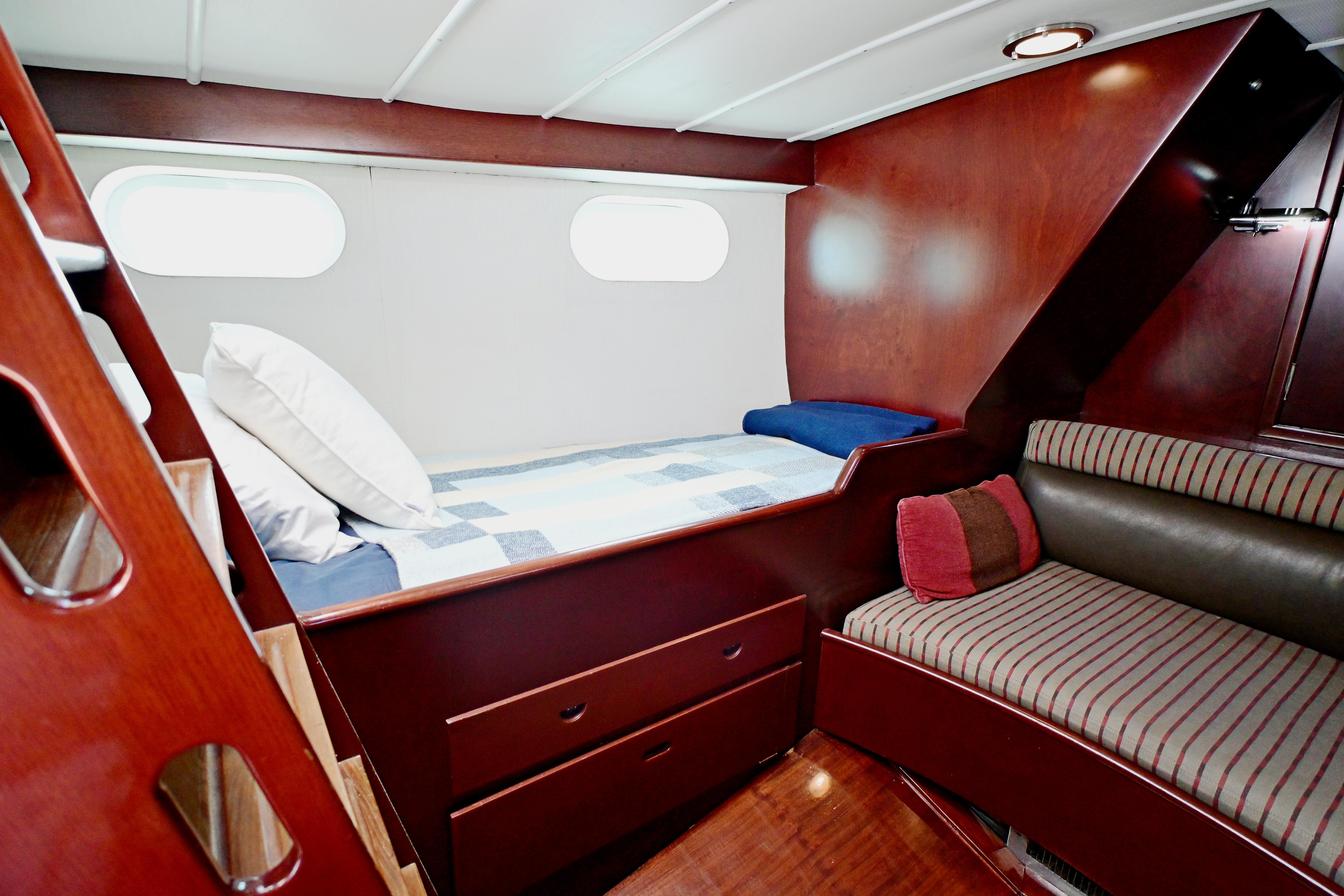 Cozy cabin interior of 1968 Abeking & Rasmussen Tripp 74 yacht with wooden furnishings.