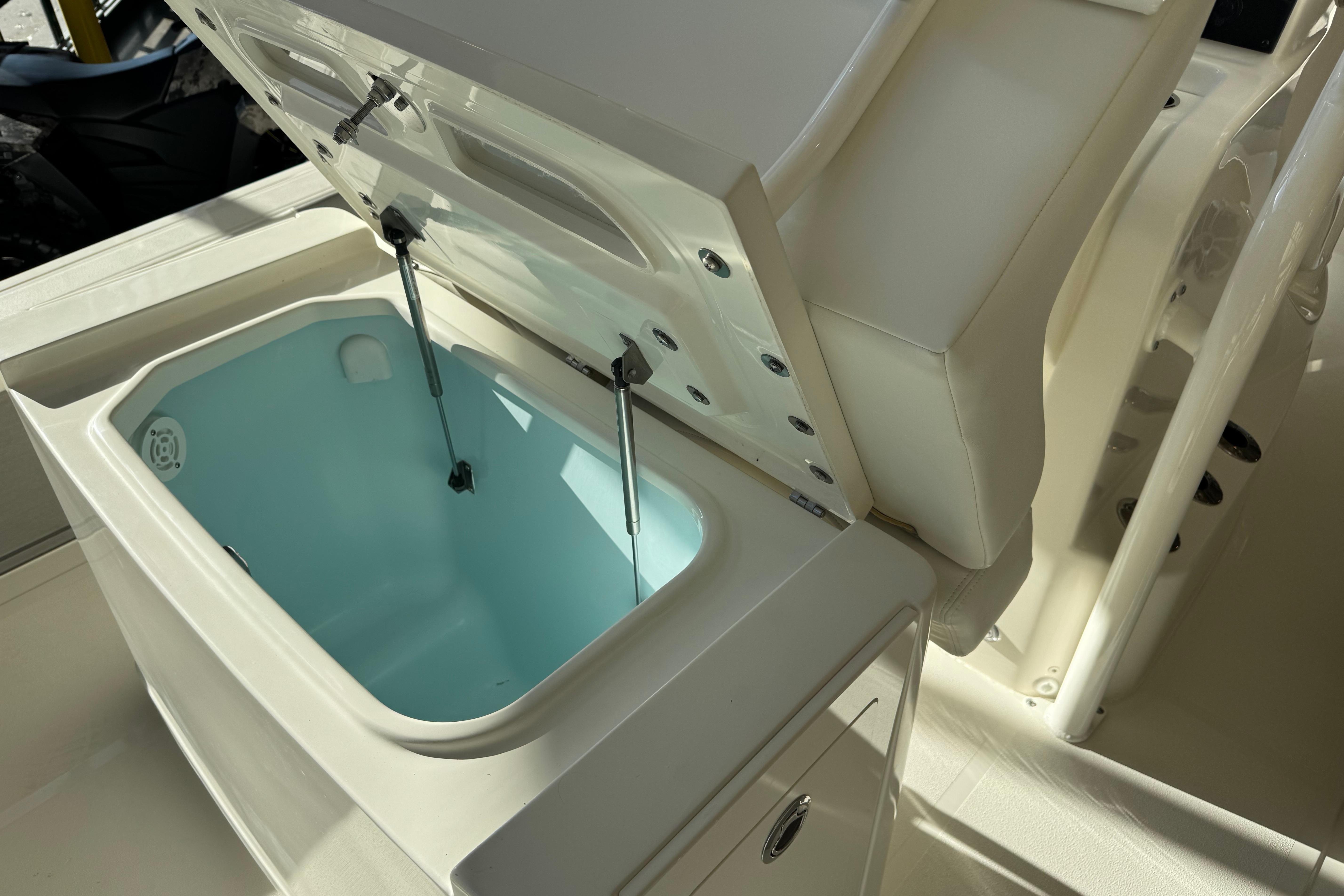 Open storage compartment on 2026 Mako 24 APEX boat, featuring a light blue interior.