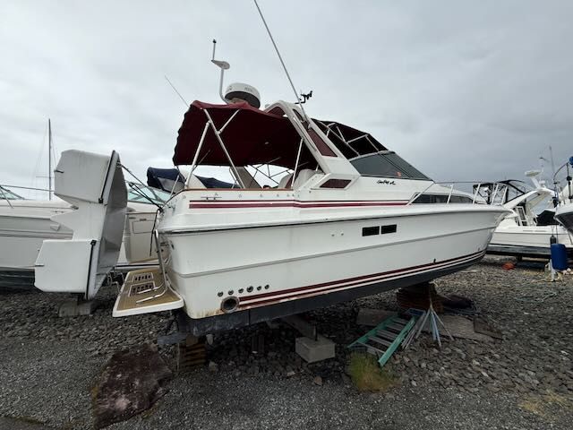 1989 Sea Ray 340 boat stored on gravel ground.
