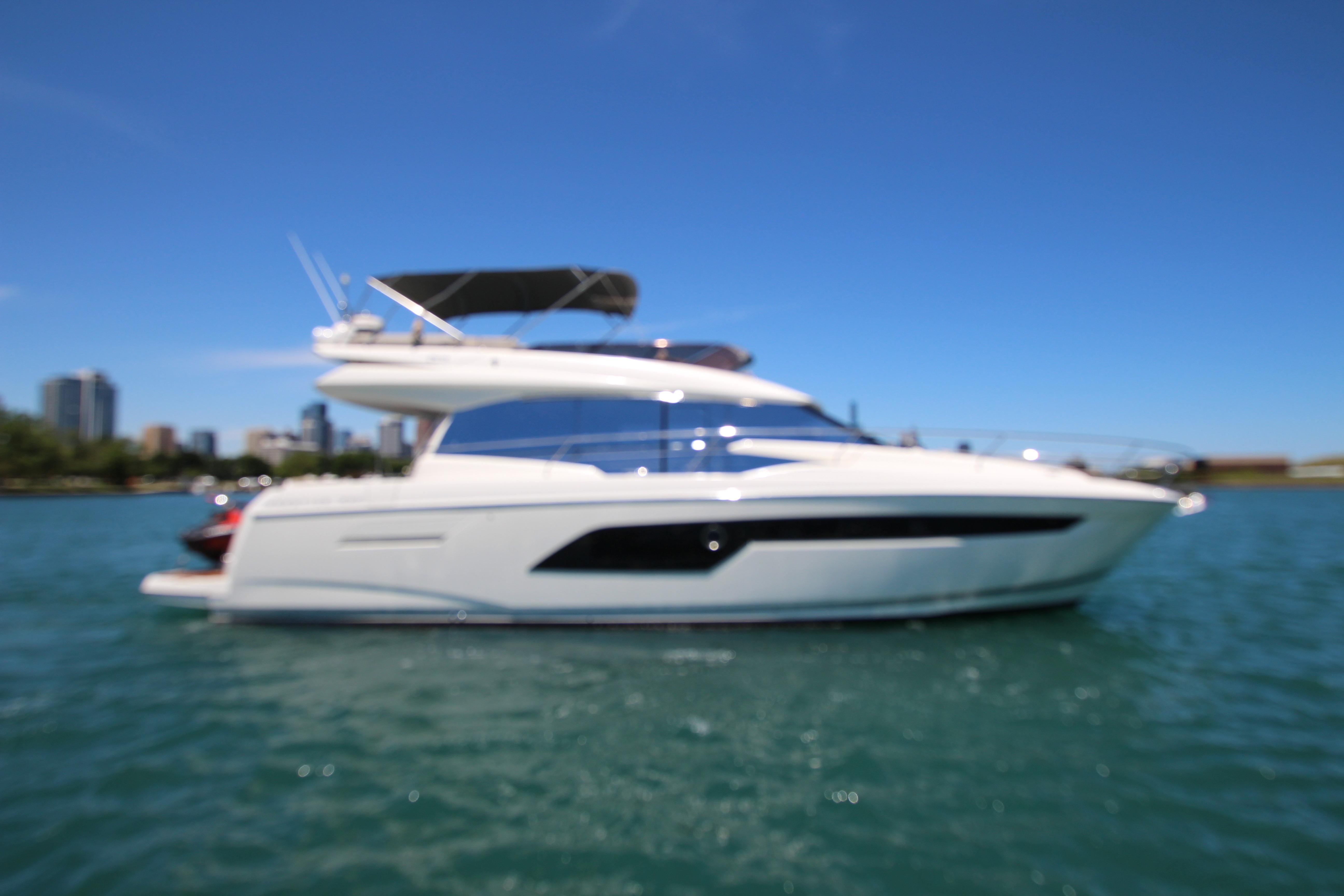 2022 Prestige 520 yacht on water with city skyline in background.