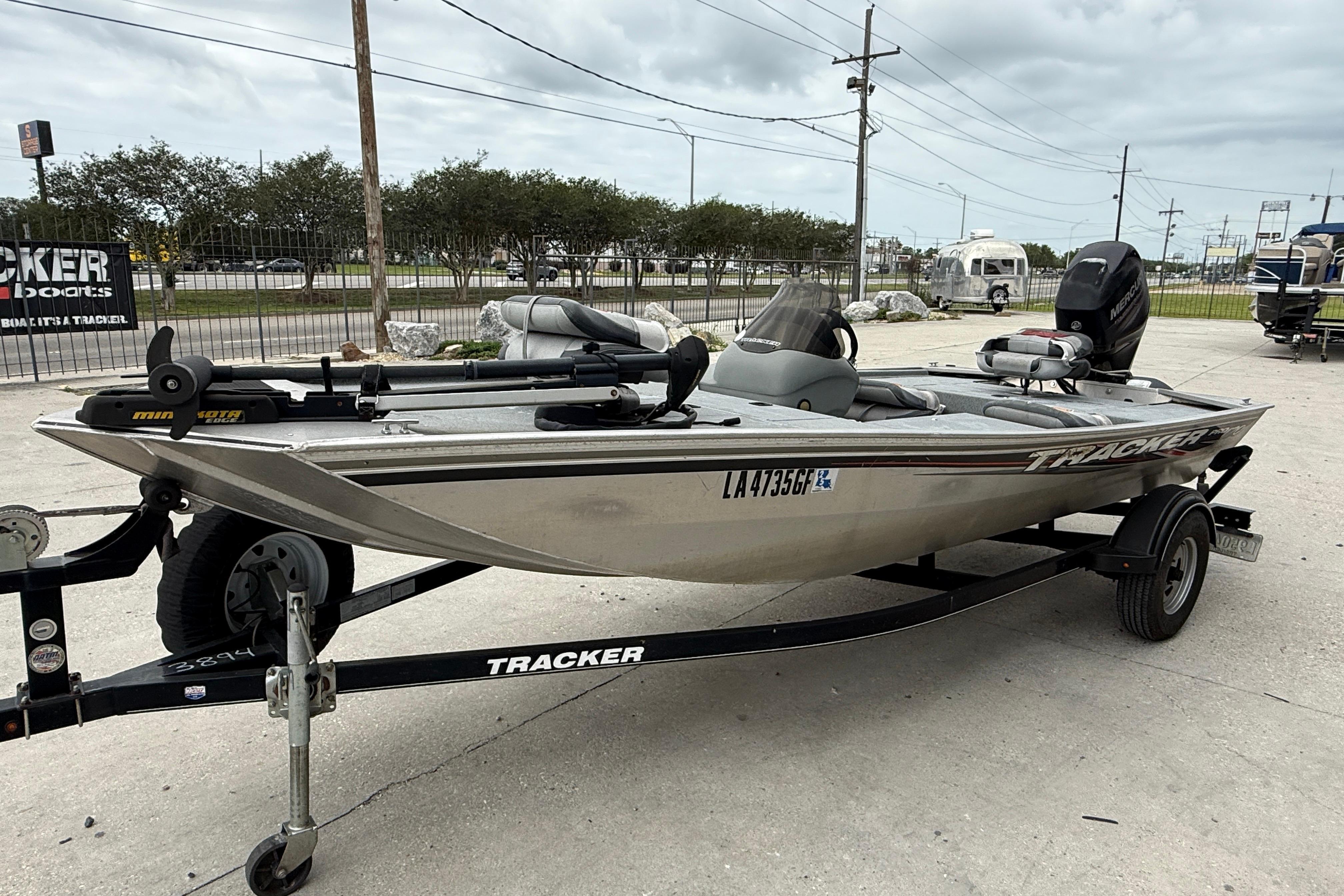2016 Tracker Pro 170 boat on trailer, parked outdoors, featuring a sleek design and motor.