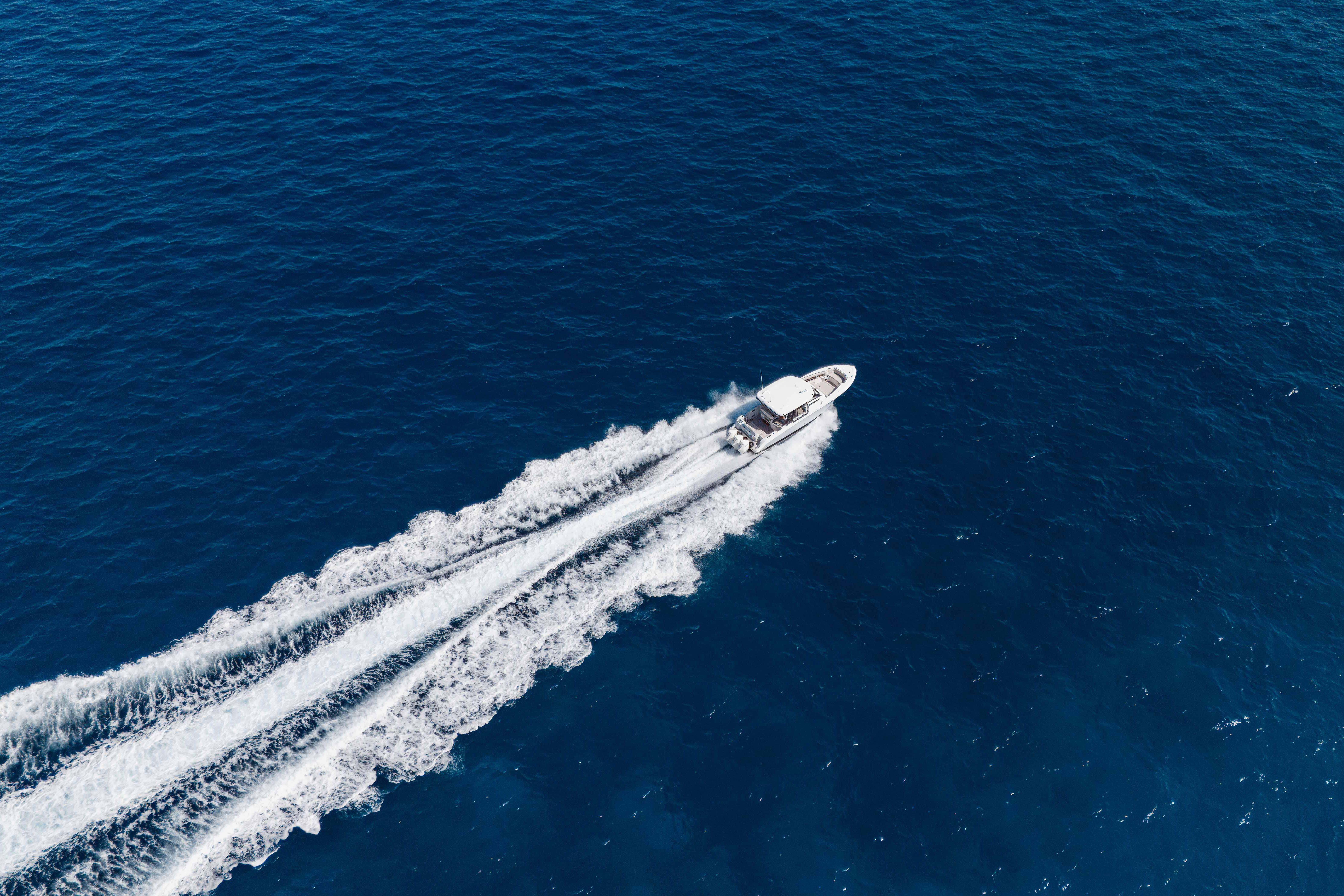 Aerial view of 2021 Boston Whaler 350 Realm cruising on open blue ocean.