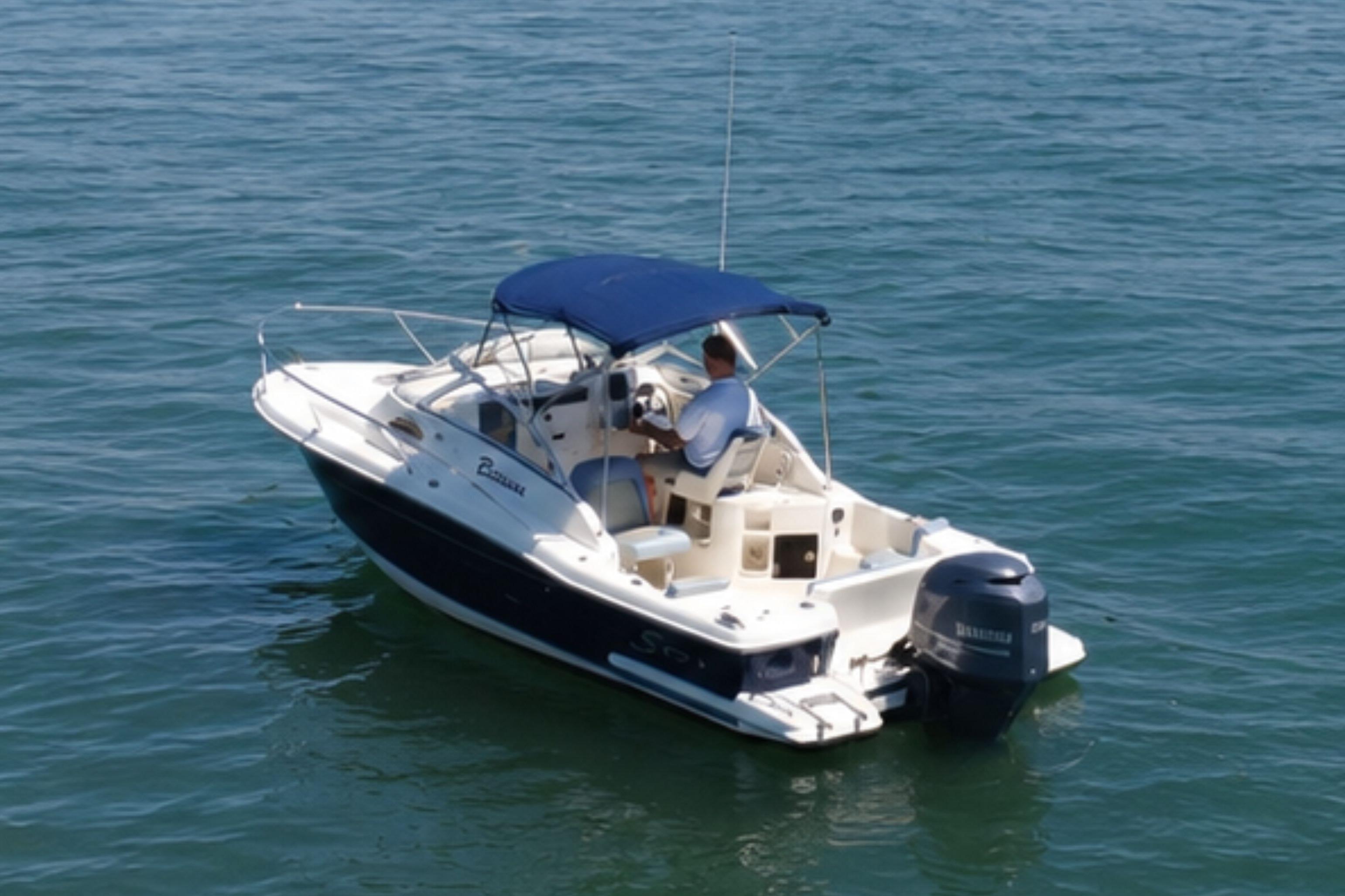 2008 Scout 222 Abaco boat with blue canopy cruising on open water.