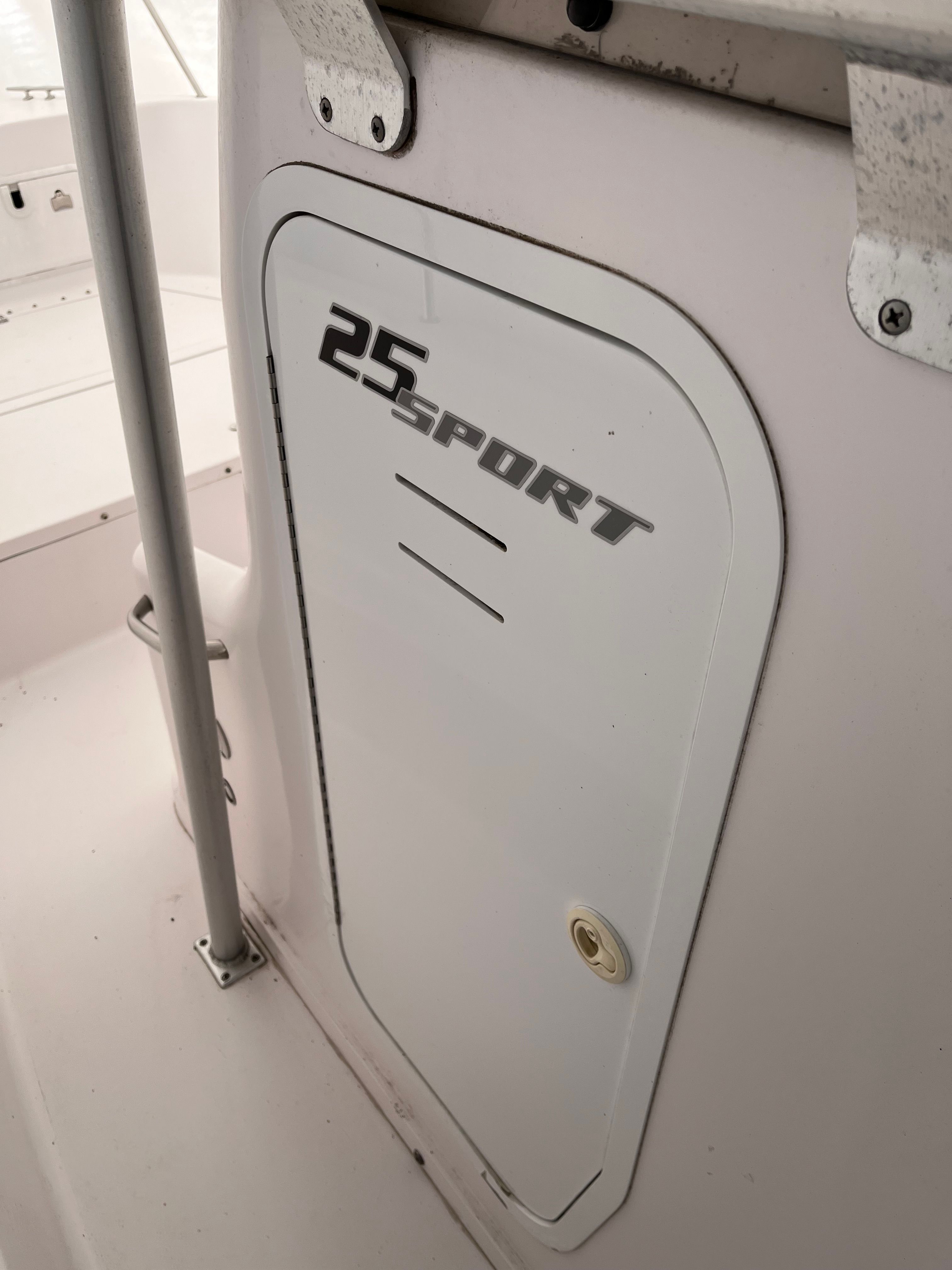 Close-up of a white boat door labeled "25 Sport."