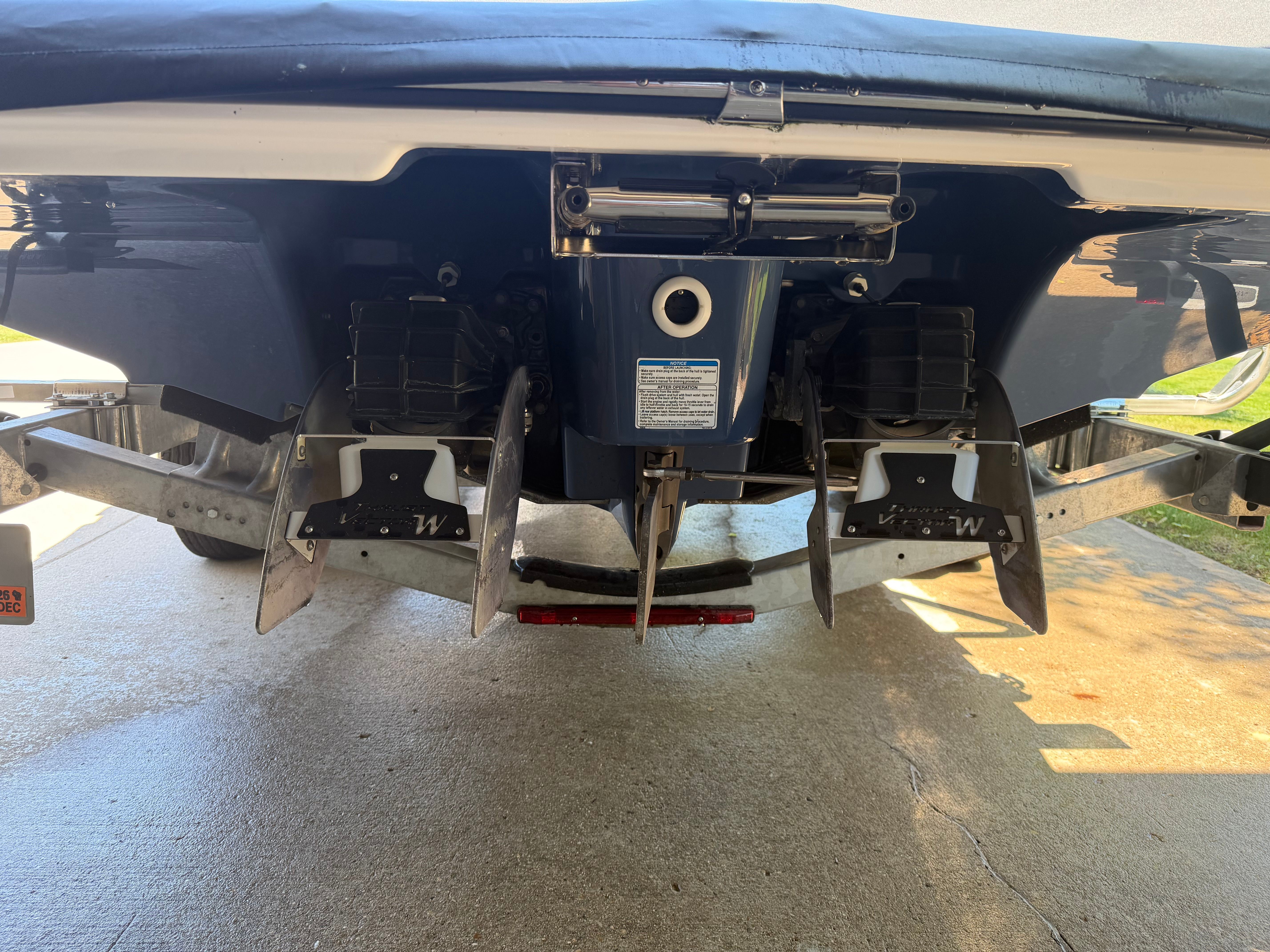 Rear view of a Yamaha 242 Limited S boat with dual propellers and a blue hull.