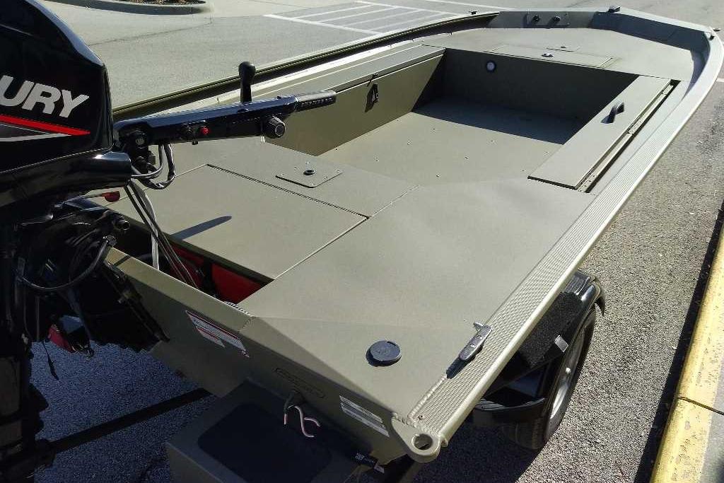 2026 Tracker Grizzly 1654 T Sportsman boat with Mercury outboard motor, parked on pavement.
