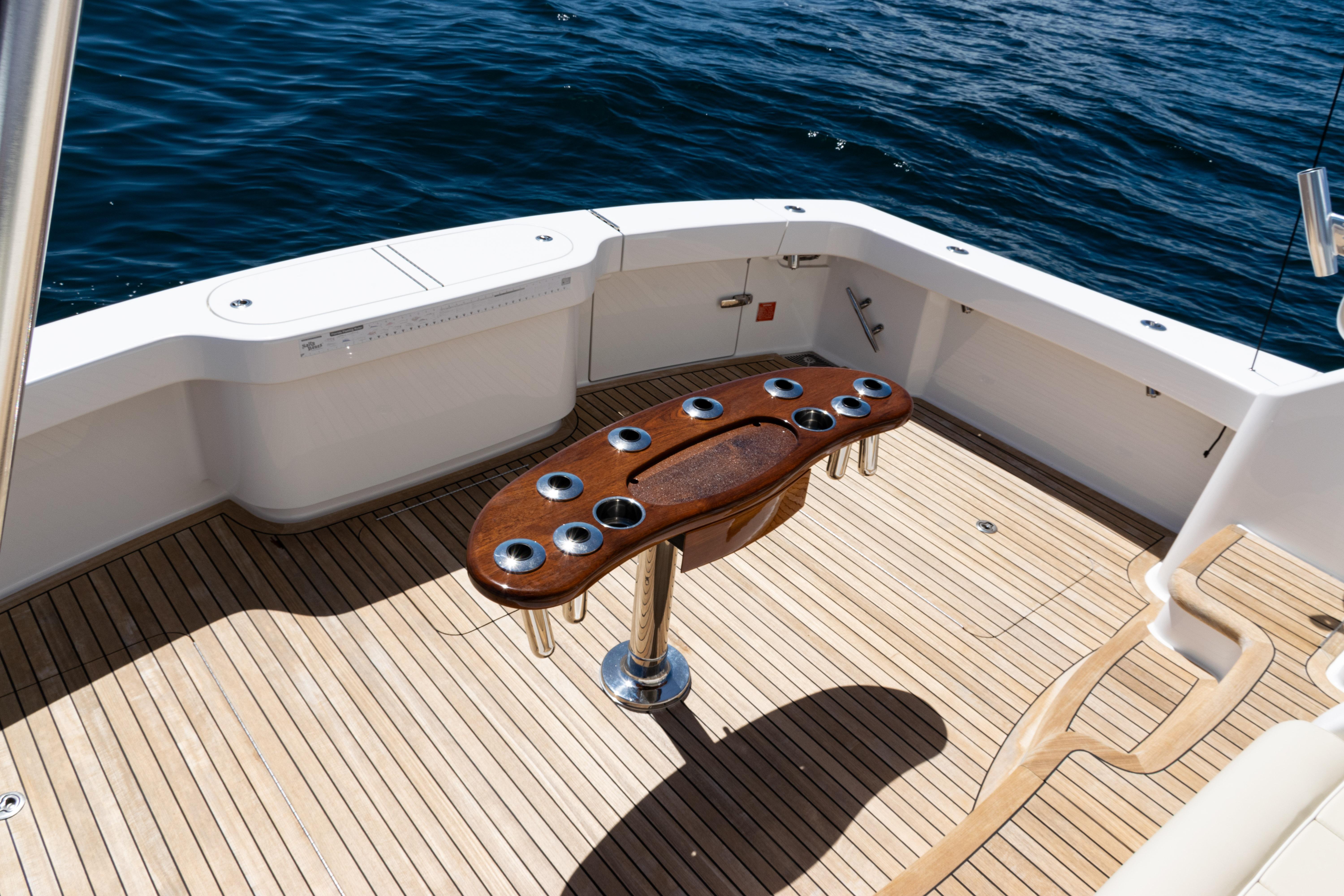 2021 Viking 44 Open yacht deck with wooden table and ocean view.