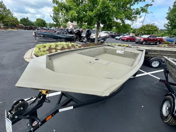 2025 Tracker GRIZZLY 1860 Utility boat on trailer in parking lot.