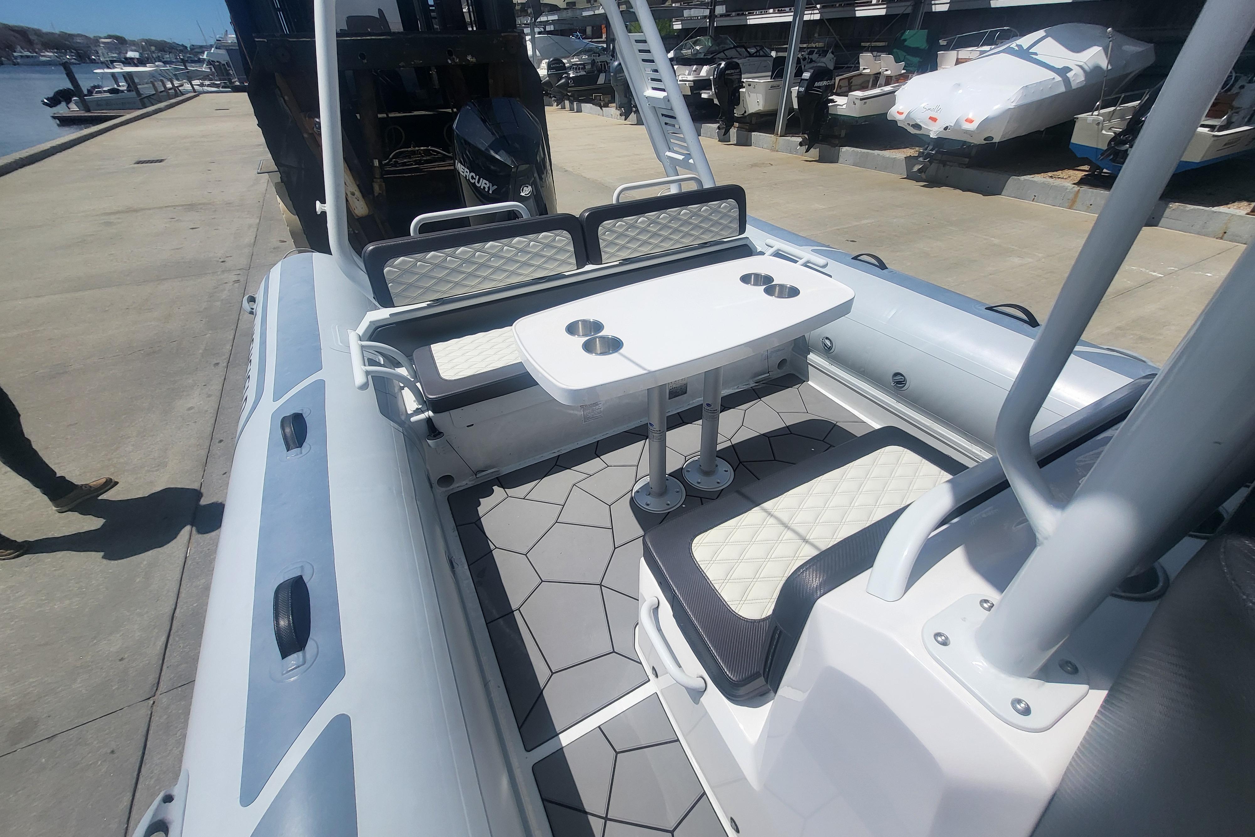 2024 Highfield Sport 760 boat interior with seating and table at a marina.
