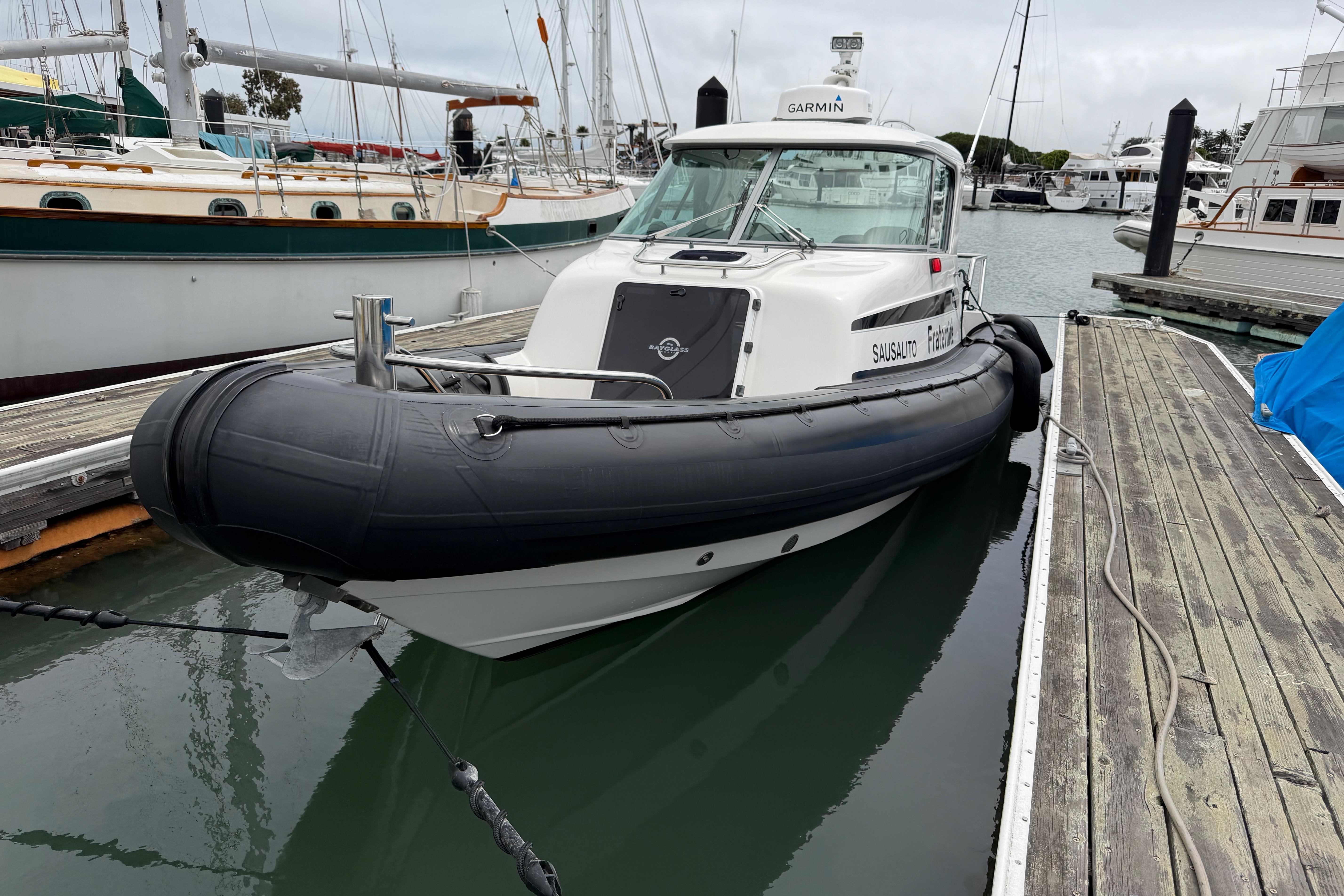 2016 Protector Targa 30 boat docked in a marina, featuring a sleek design and inflatable collar.