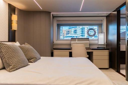 Luxurious Sunseeker 90 Ocean 2025 yacht bedroom with modern decor and large window view.